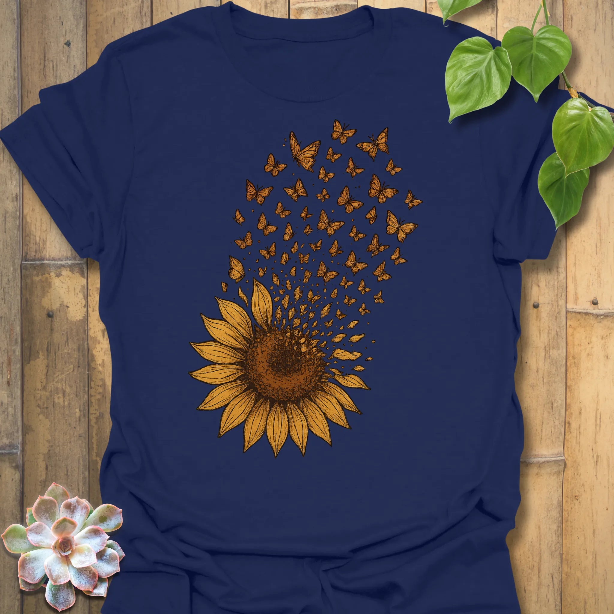 A bold navy tee featuring a radiant sunflower bursting into butterflies — the perfect mix of strength and serenity for nature lovers.