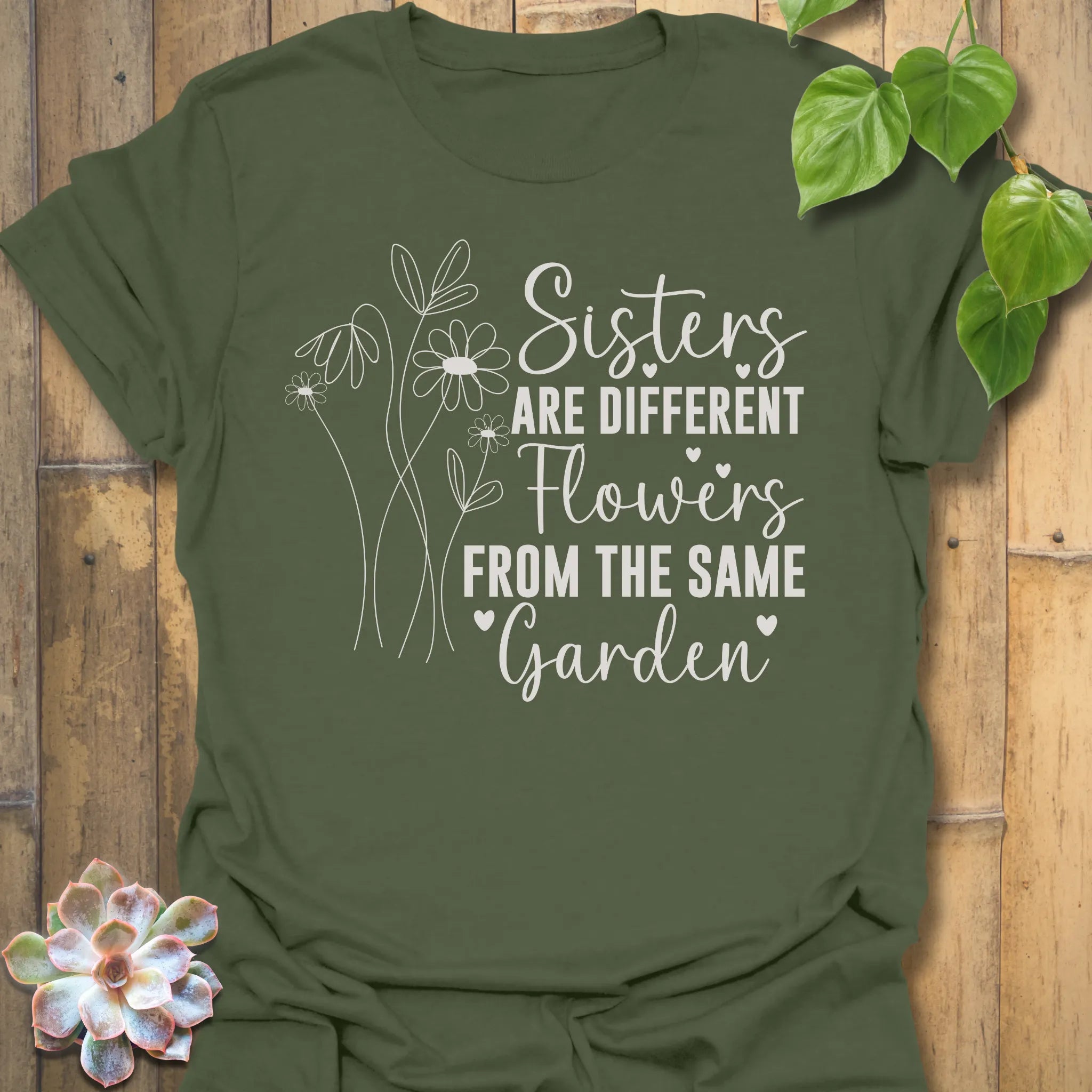 Military Green t-shirt with floral design and text on a wooden background