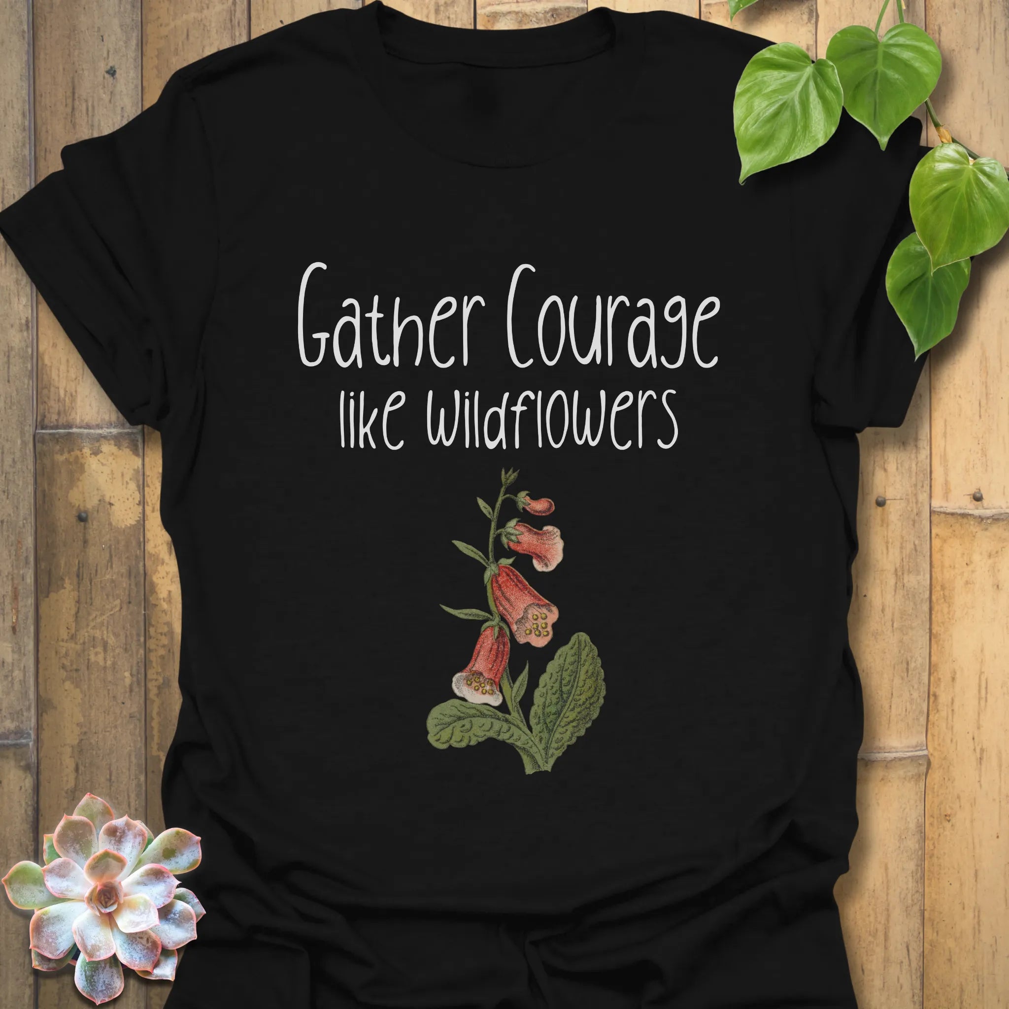 Black floral inspirational t-shirt featuring the phrase ‘Gather courage like wildflowers’ and a soft flower design