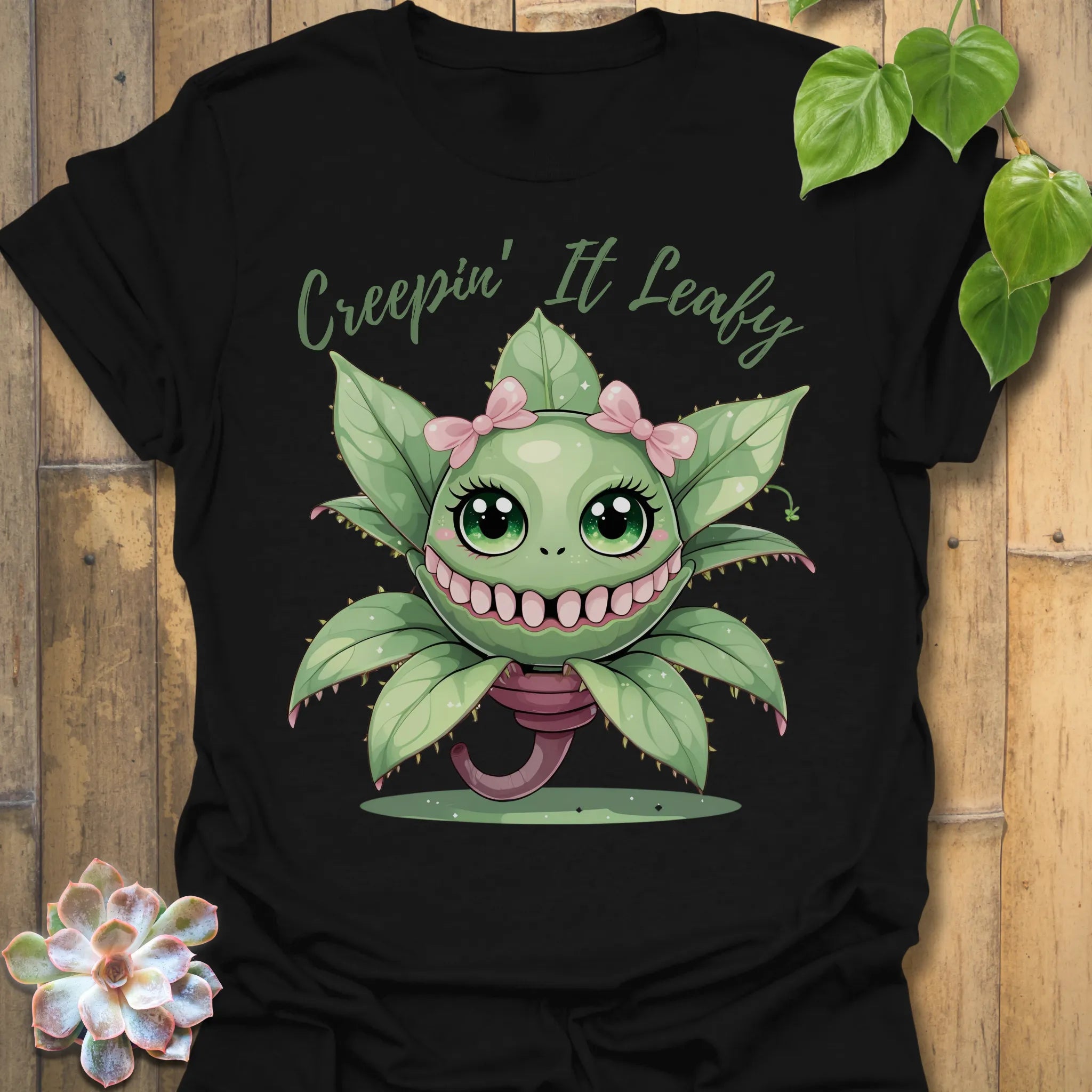 Black t-shirt featuring the design Creepin’ It Leafy printed in bold black letters, gardening graphic shirt.
