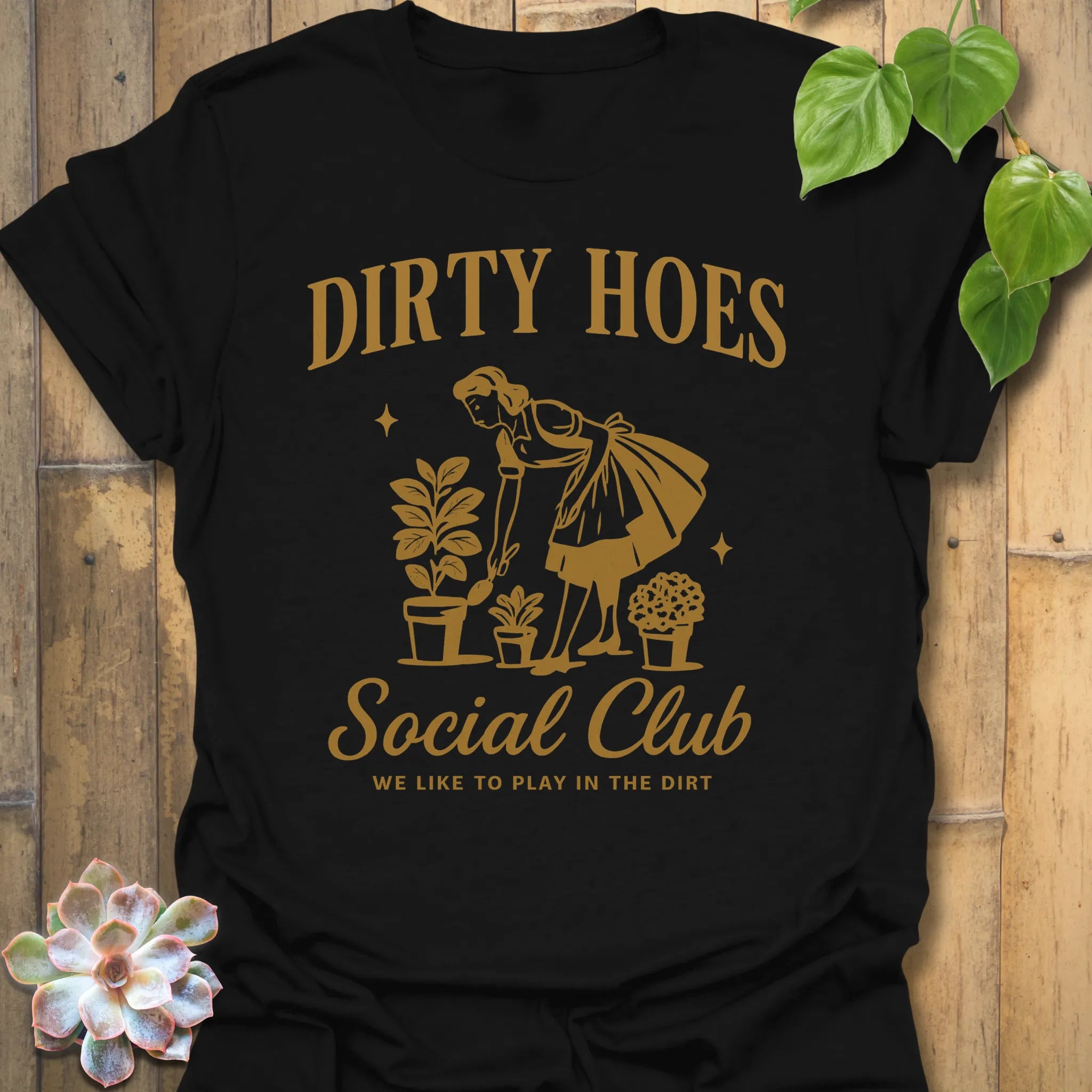 Black t-shirt featuring the design Dirty Hoes printed in bold letters, gardening graphic tee.