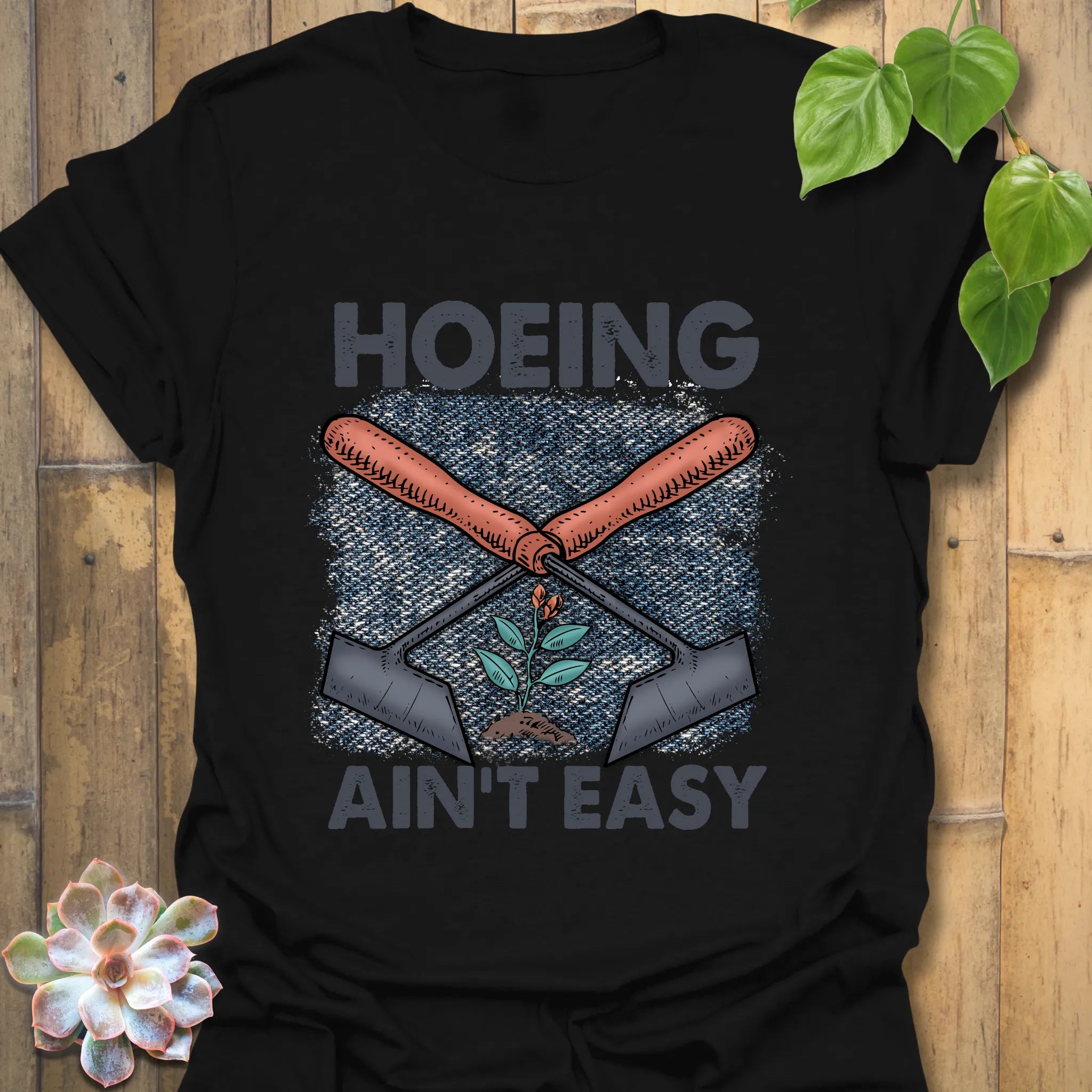 Black t-shirt featuring the design Hoeing Ain’t Easy, witty garden work shirt.