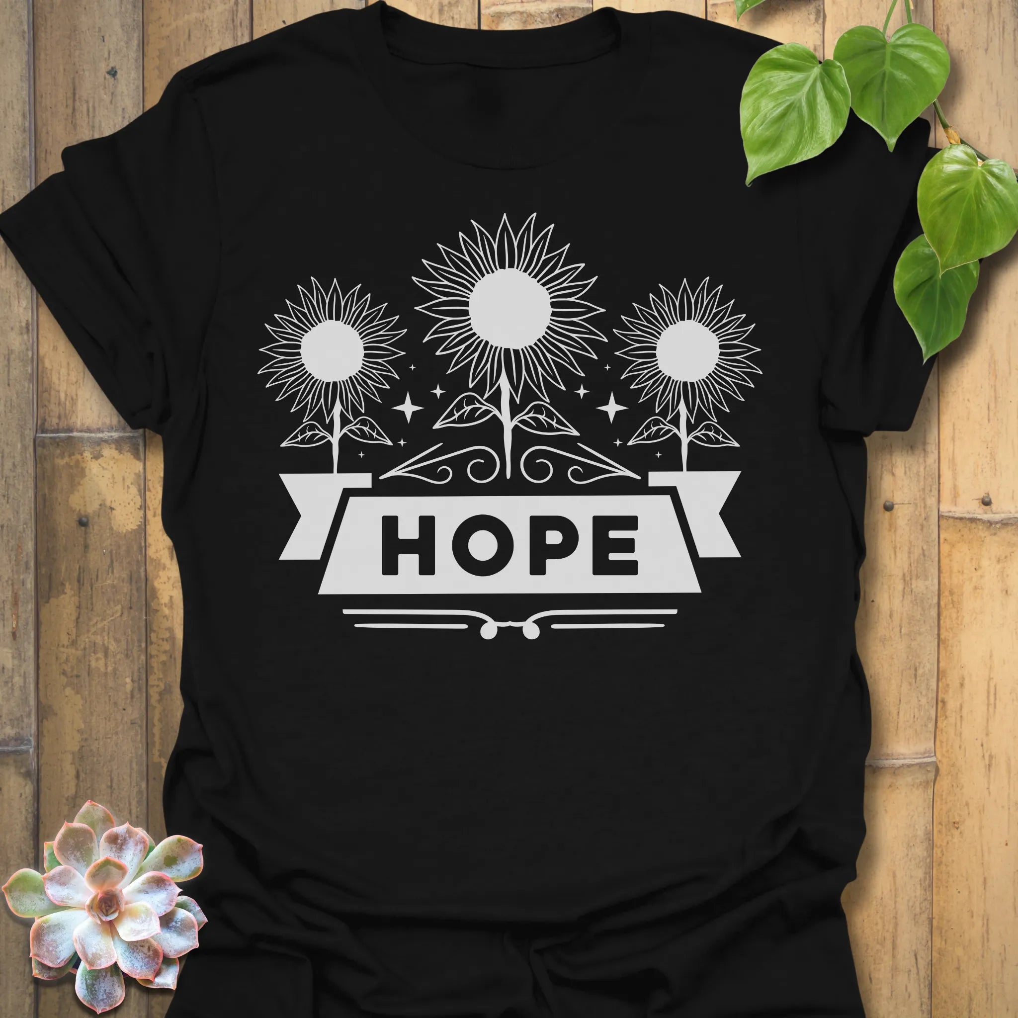 Black t-shirt featuring the design Hope printed in sunflower and bold letters, positive vibe t-shirt.