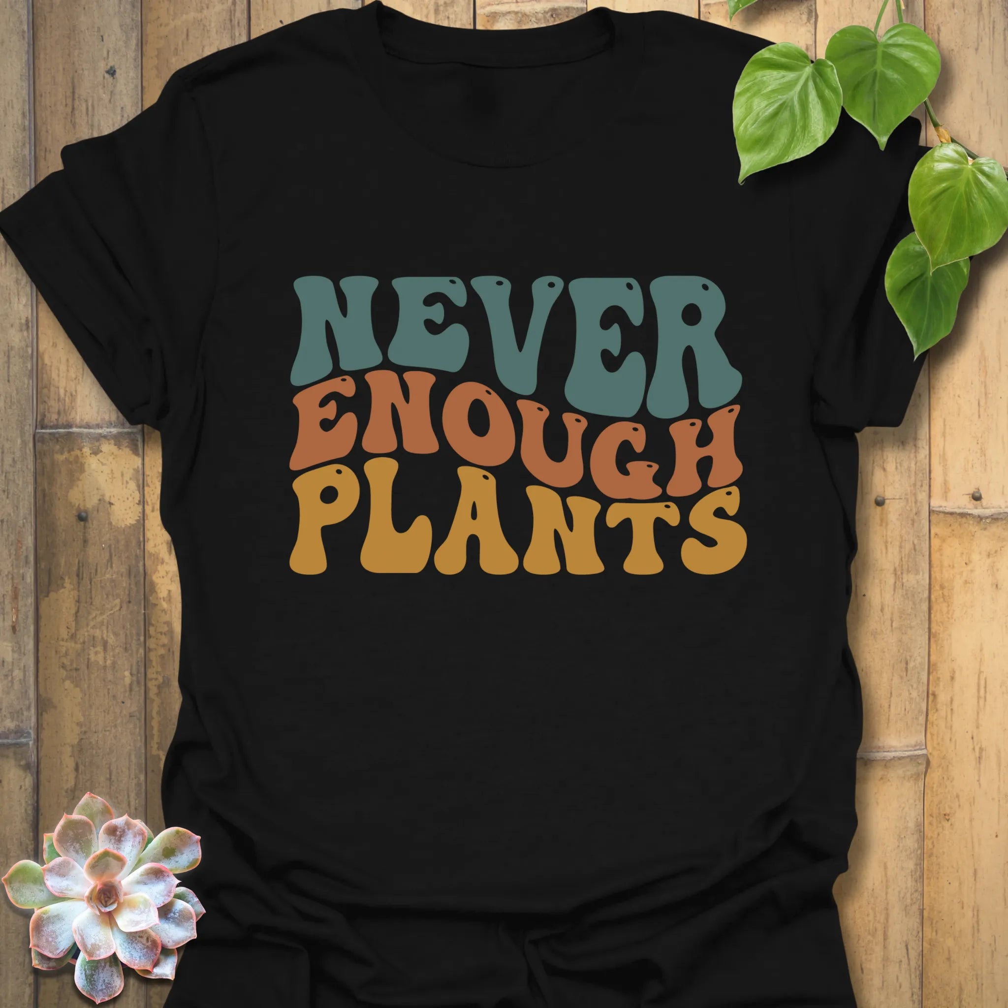 Black t-shirt featuring the design Never Enough Plants in bold green letters with a leaf accent.