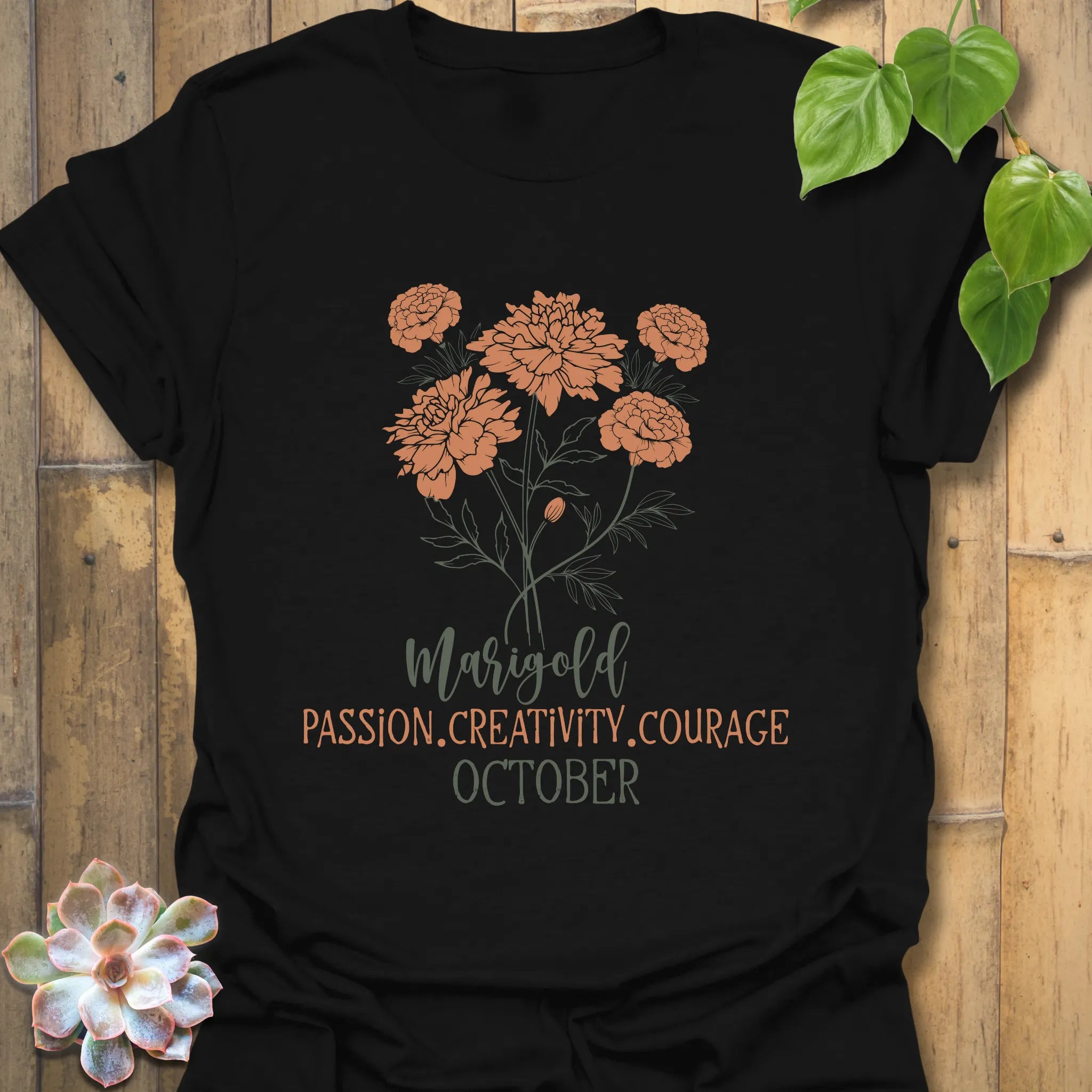 Black t-shirt featuring the design October Marigold printed with a striking marigold flower, a trendy flower print graphic shirt.