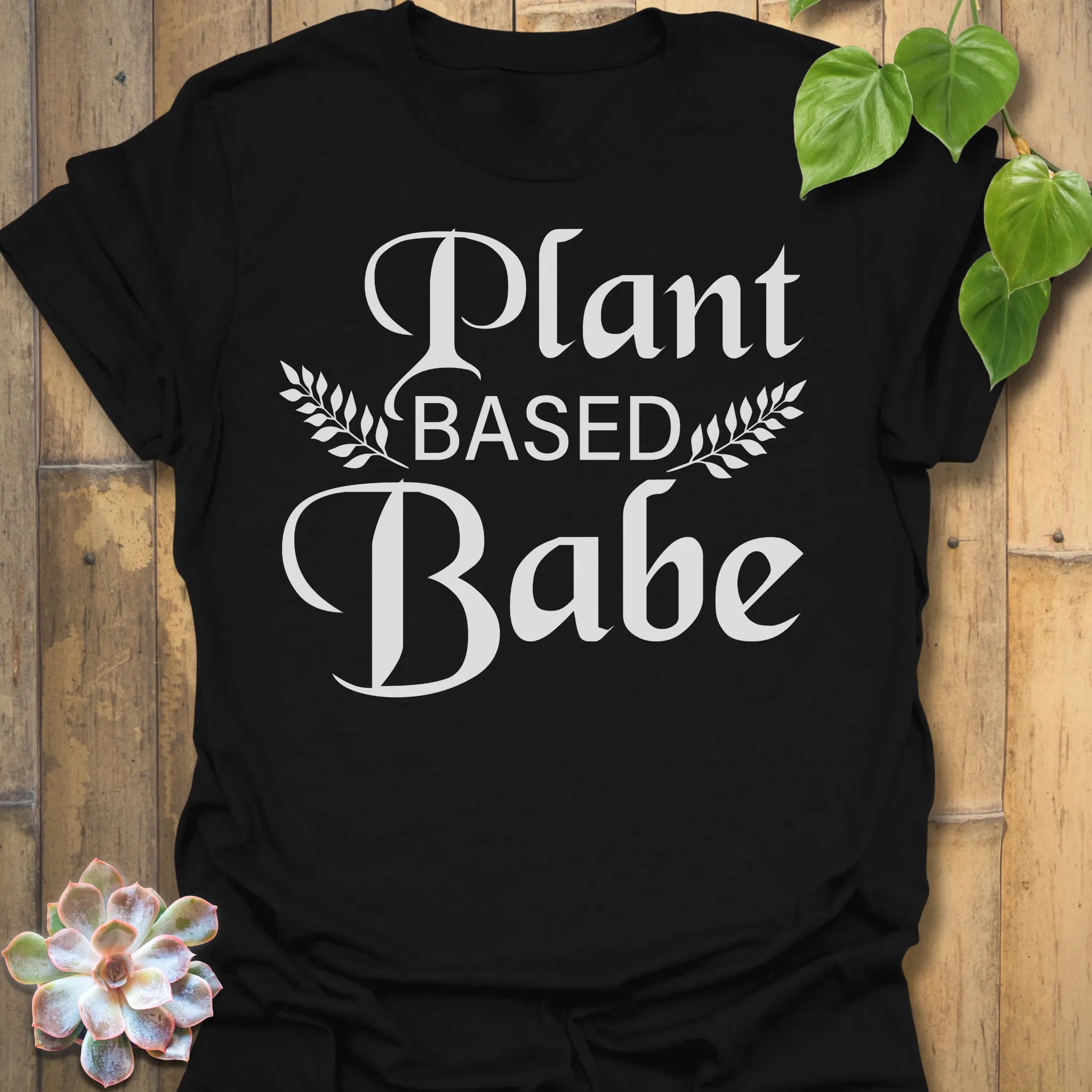 Black t-shirt featuring the design Plant Based Babe printed in bold white letters, plant lover vegan shirt.