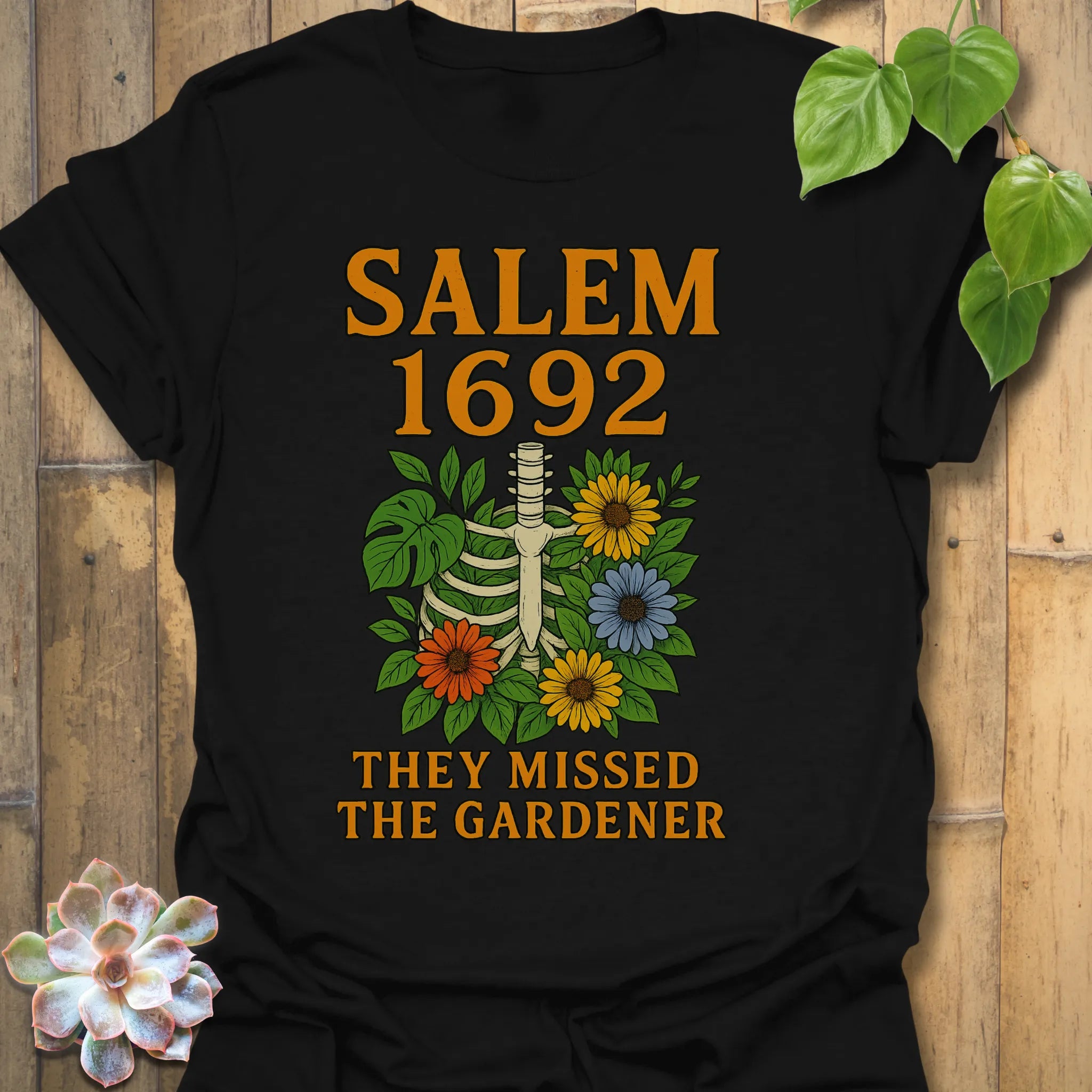 Black t-shirt featuring the design Salem 1692 printed in bold letters, vintage halloween graphic tee.