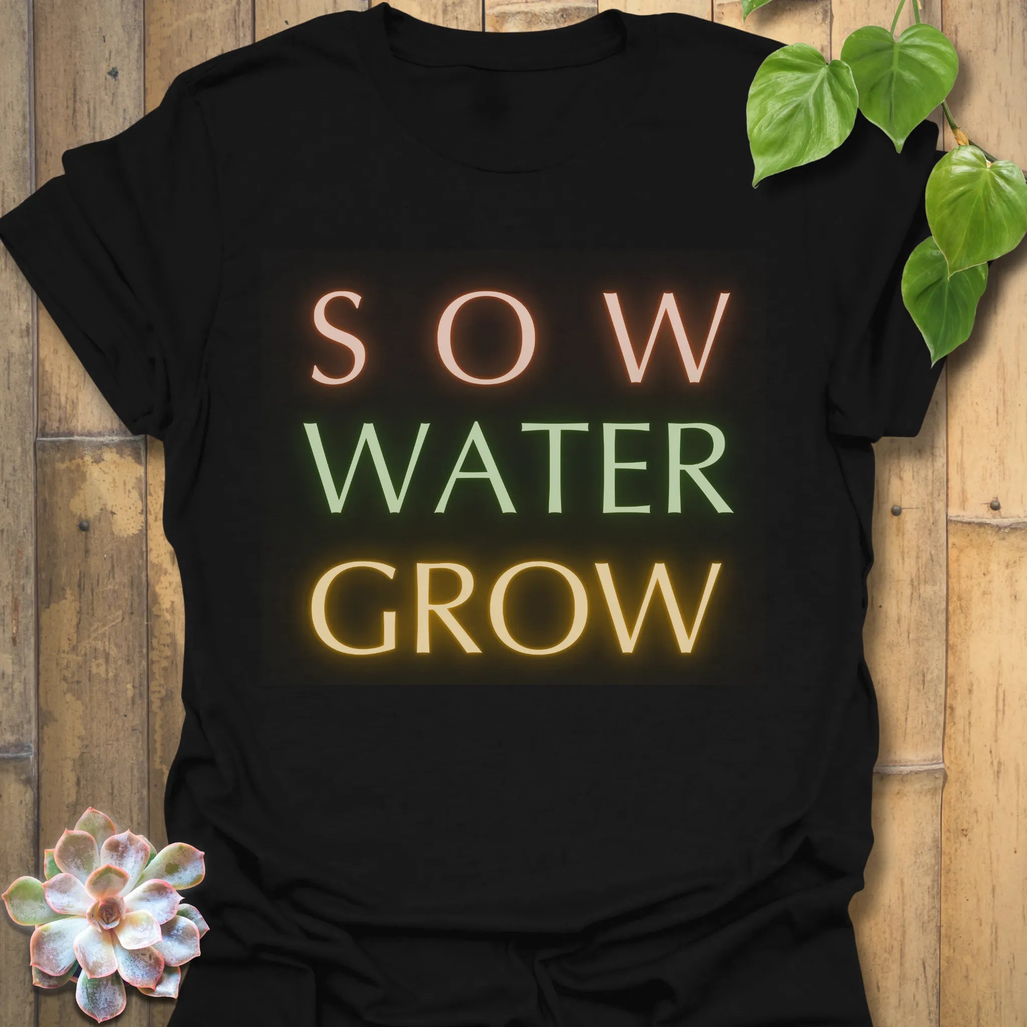 Black t-shirt featuring the design Sow Water Grow printed with eco-friendly plant and water graphic.