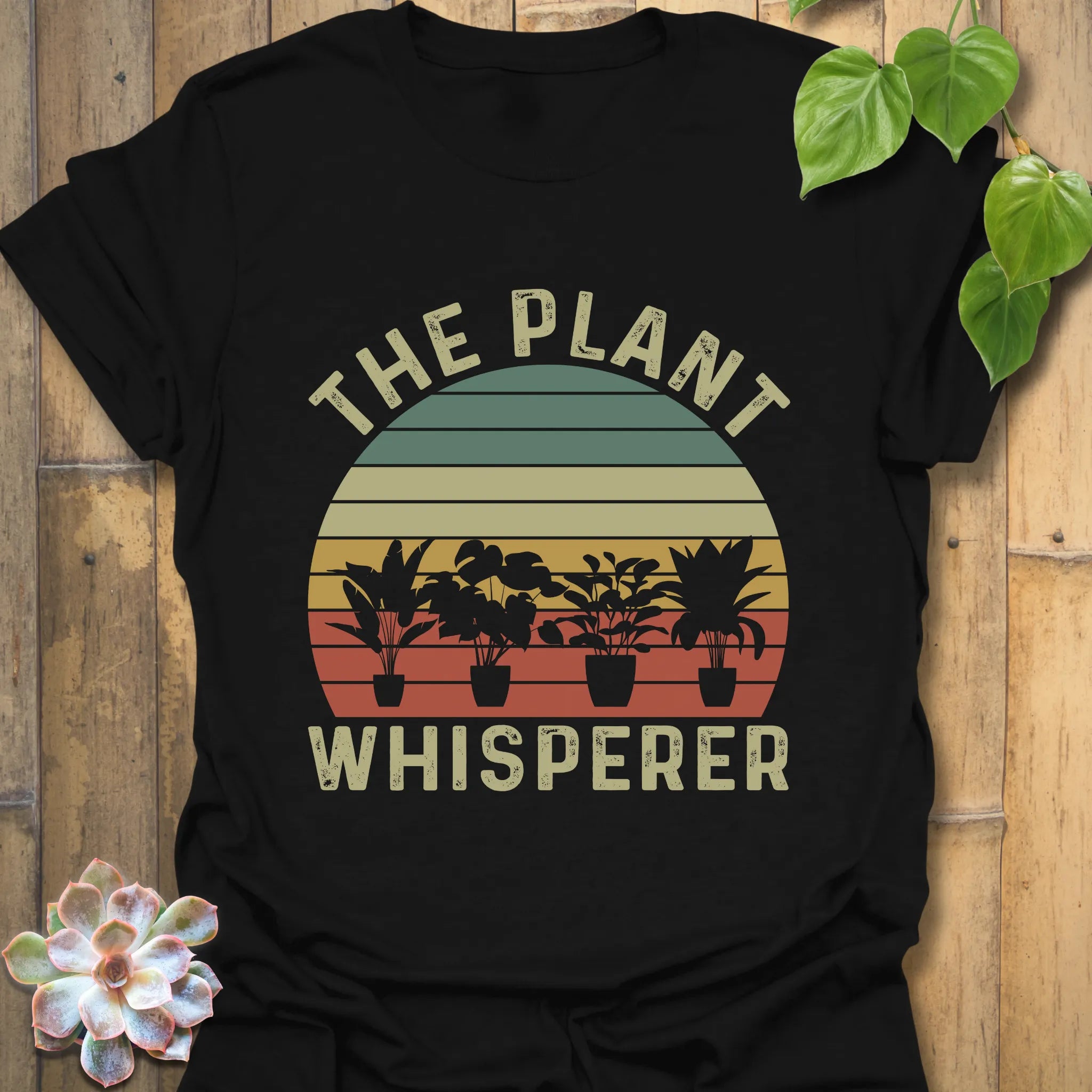 Black t-shirt featuring the design The Plant Whisperer with a plant in a pot printed, a trendy plant lover shirt for gardeners