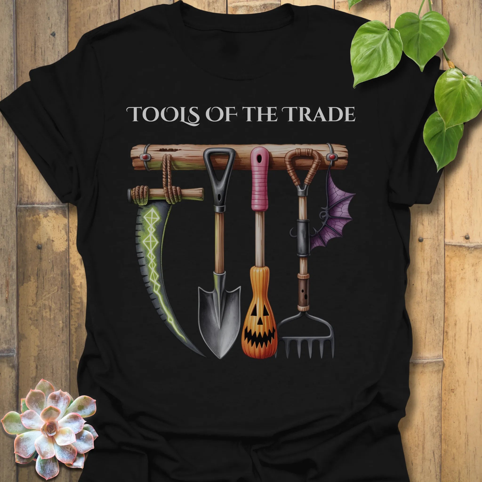 Black t-shirt featuring the design Tools Of The Trade printed in bold letters, garden tools shirt.