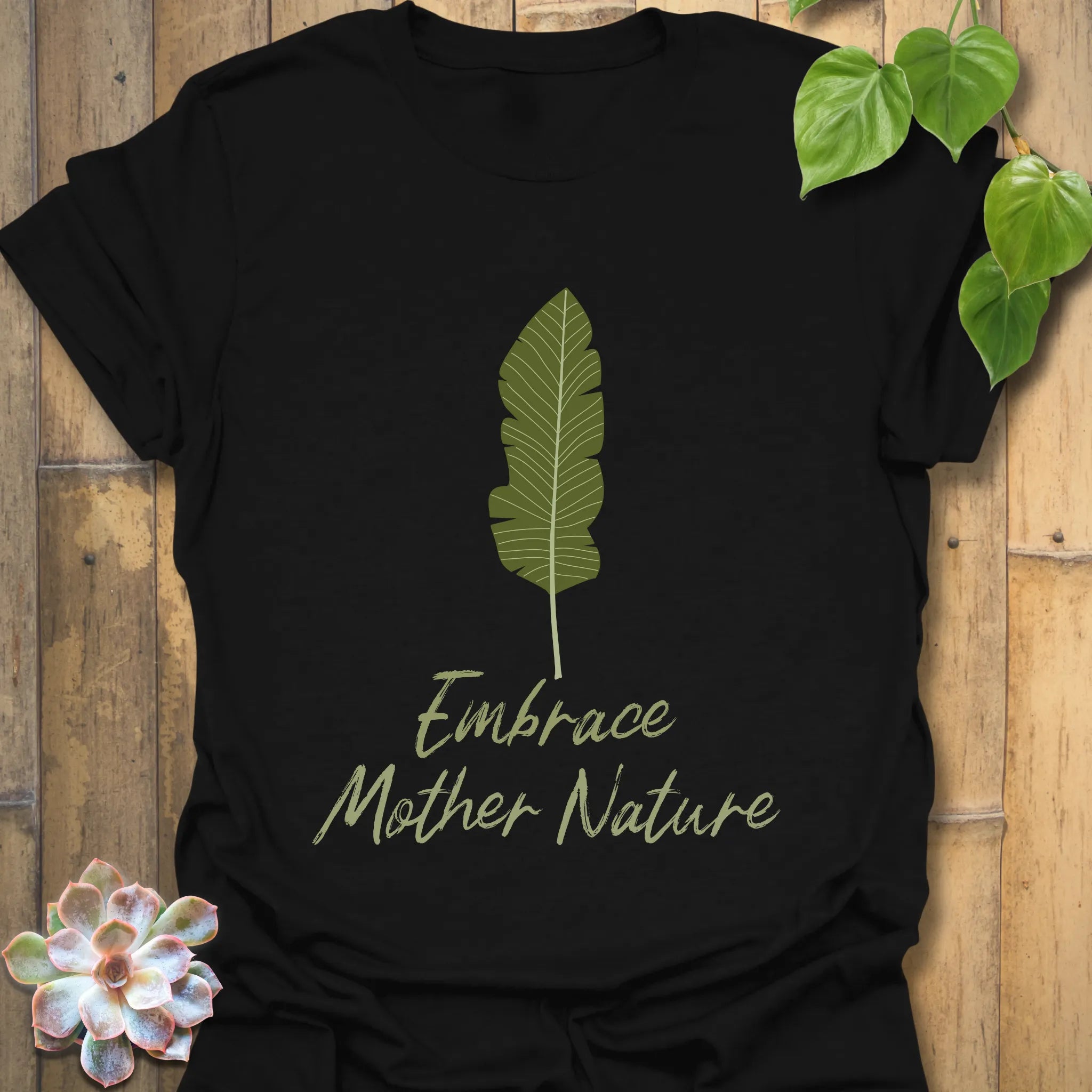 Black t-shirt showing the phrase “Embrace Mother Nature” paired with a leafy print design