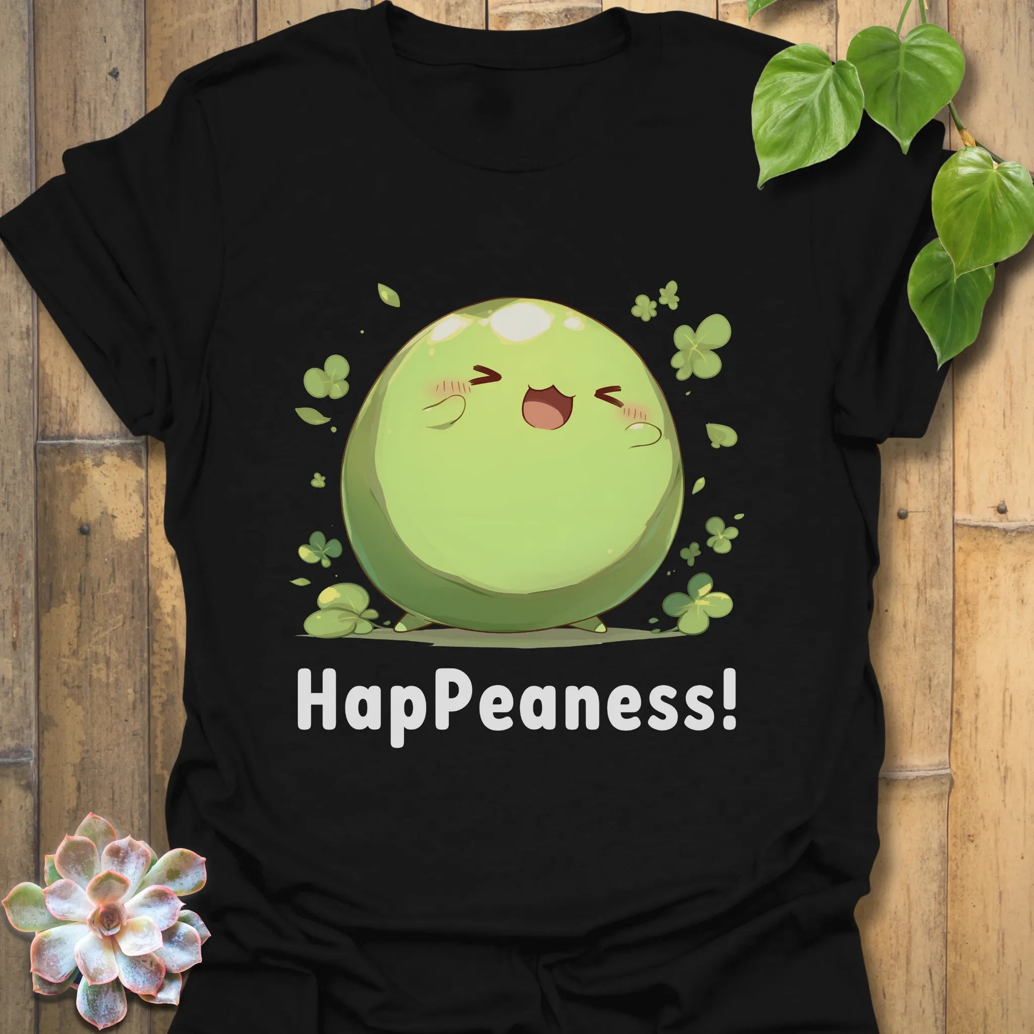 Black t-shirt with a cute green pea illustration surrounded by clovers and the text “HapPeaness!”