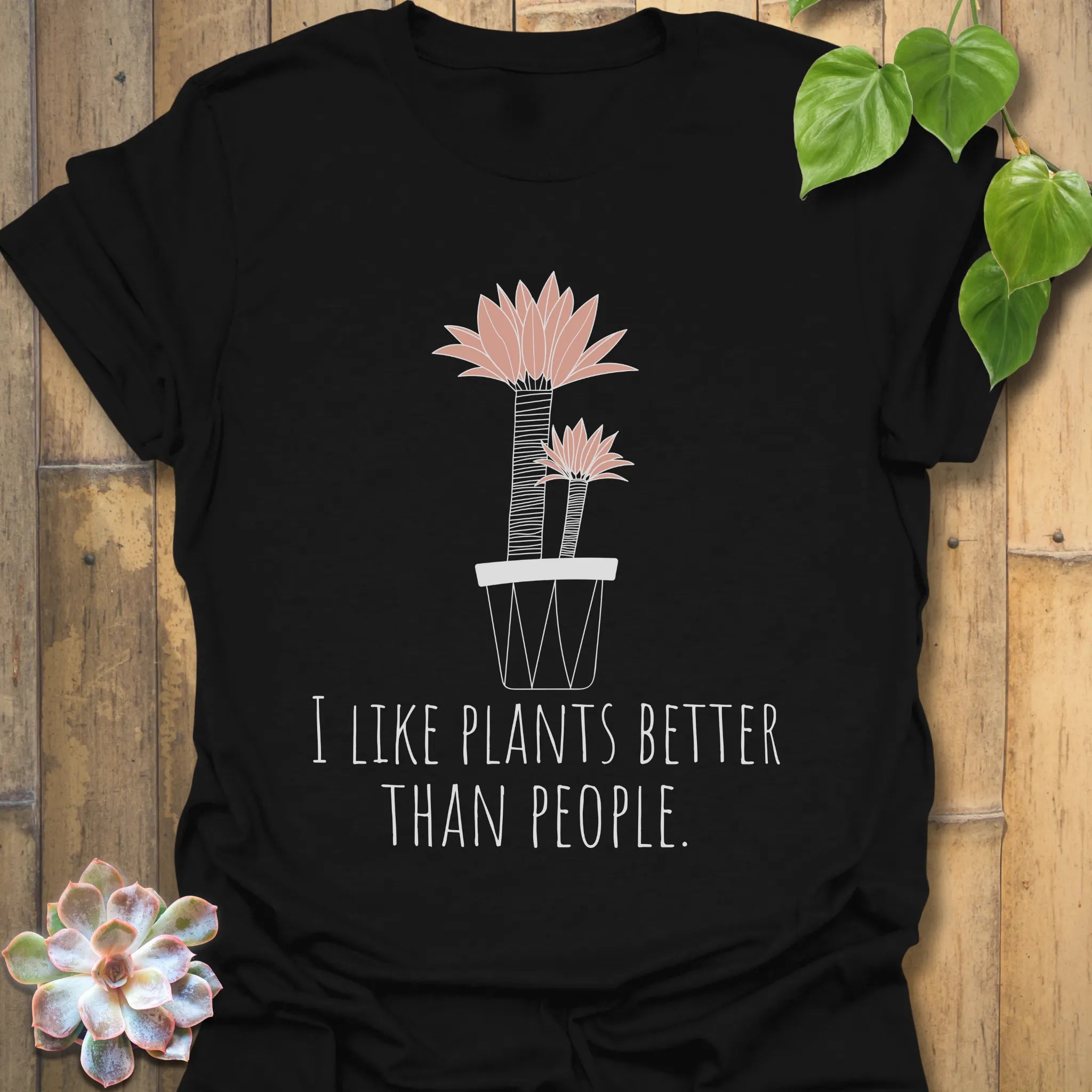 Black t-shirt with the phrase “I like plants better than people” and a flower in a pot printed on the front