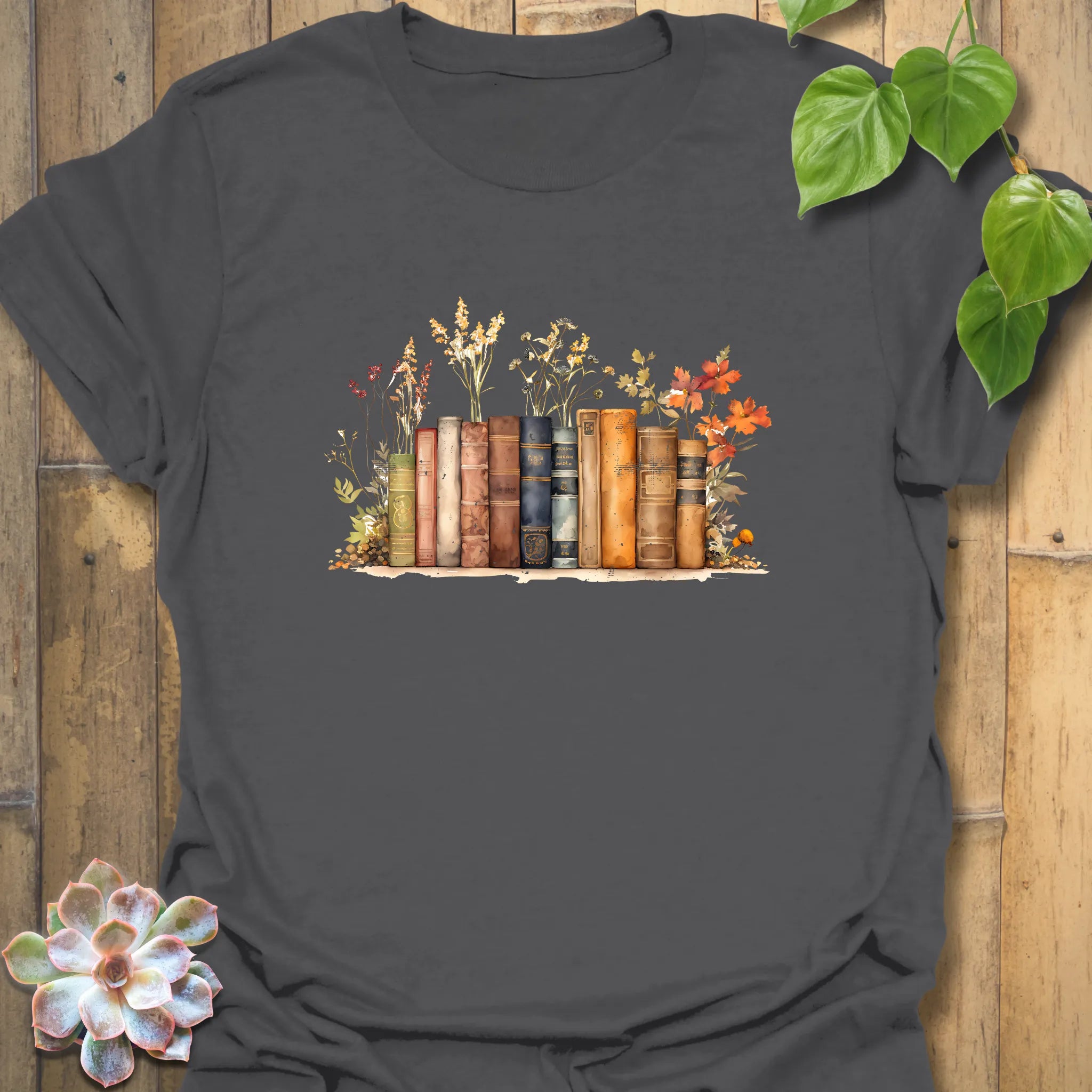 Charcoal “Wildflower Library” T-shirt showcasing a colourful stack of books with wildflowers — elegant design on soft Gildan 64000 cotton.