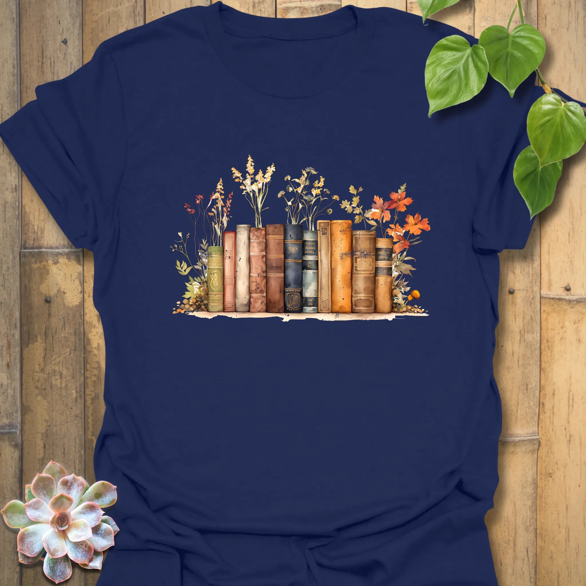Navy “Wildflower Library” T-shirt with a colourful vintage book stack and wildflowers design — cosy and classic for book lovers.