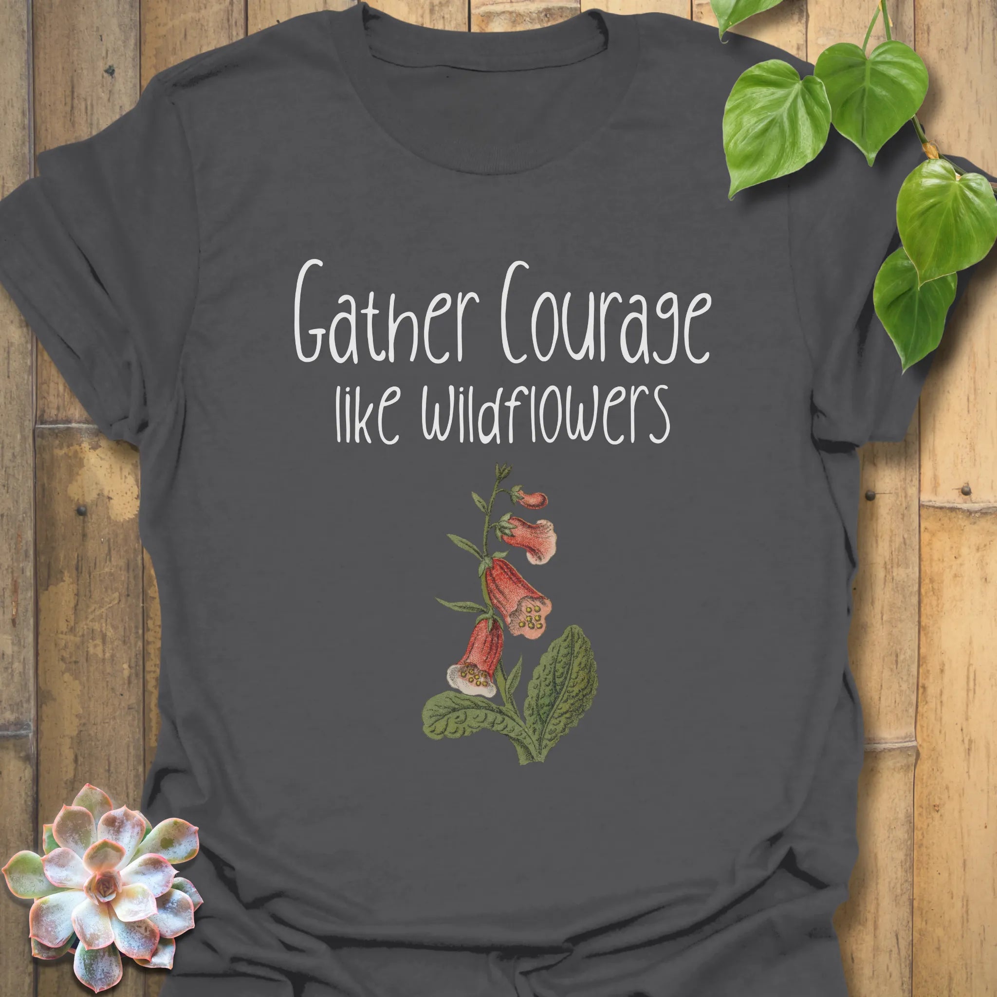 Charcoal botanical graphic t-shirt featuring the uplifting phrase ‘Gather courage like wildflowers’ with a detailed flower print