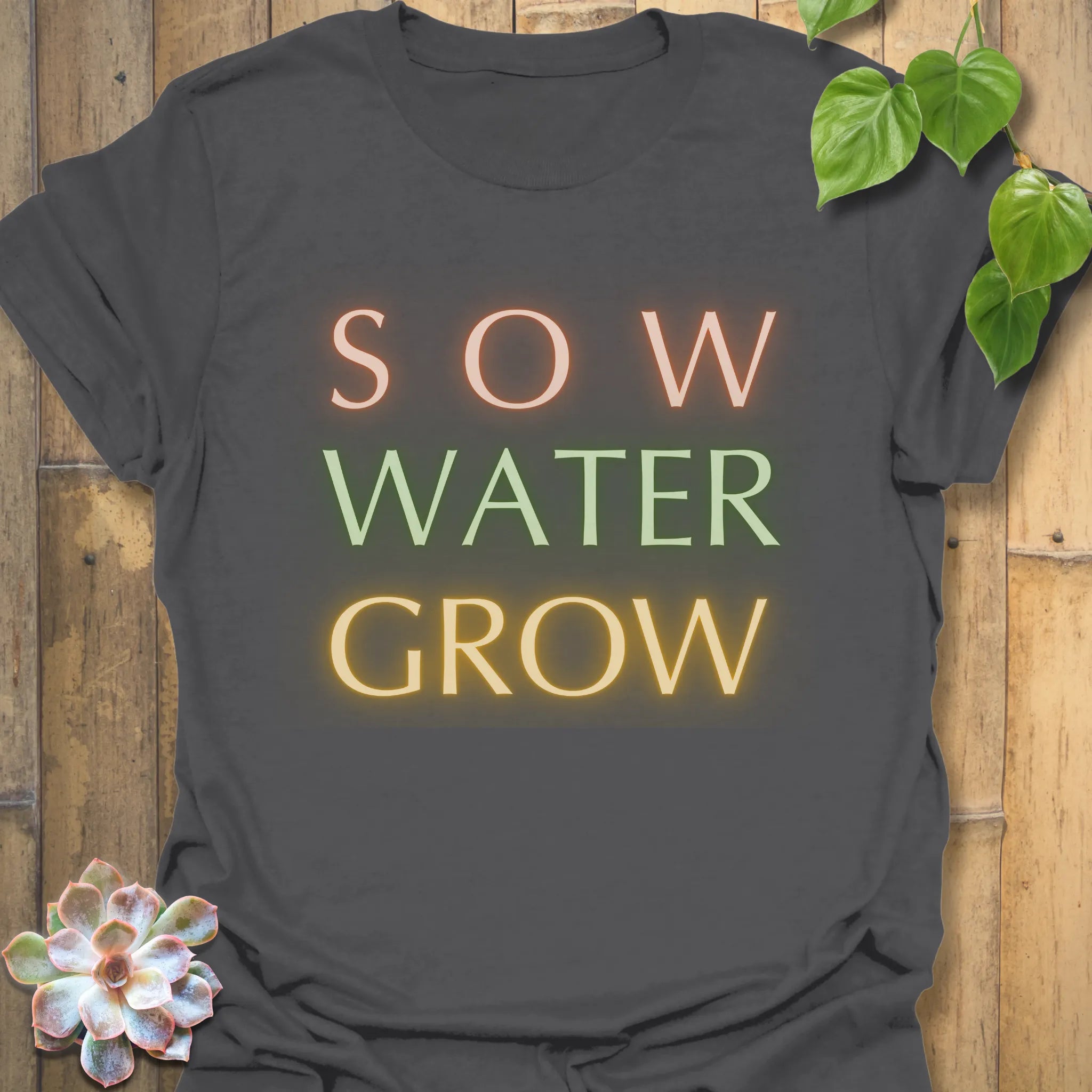 Charcoal t-shirt featuring the design Sow Water Grow printed with a nature and plant illustration.