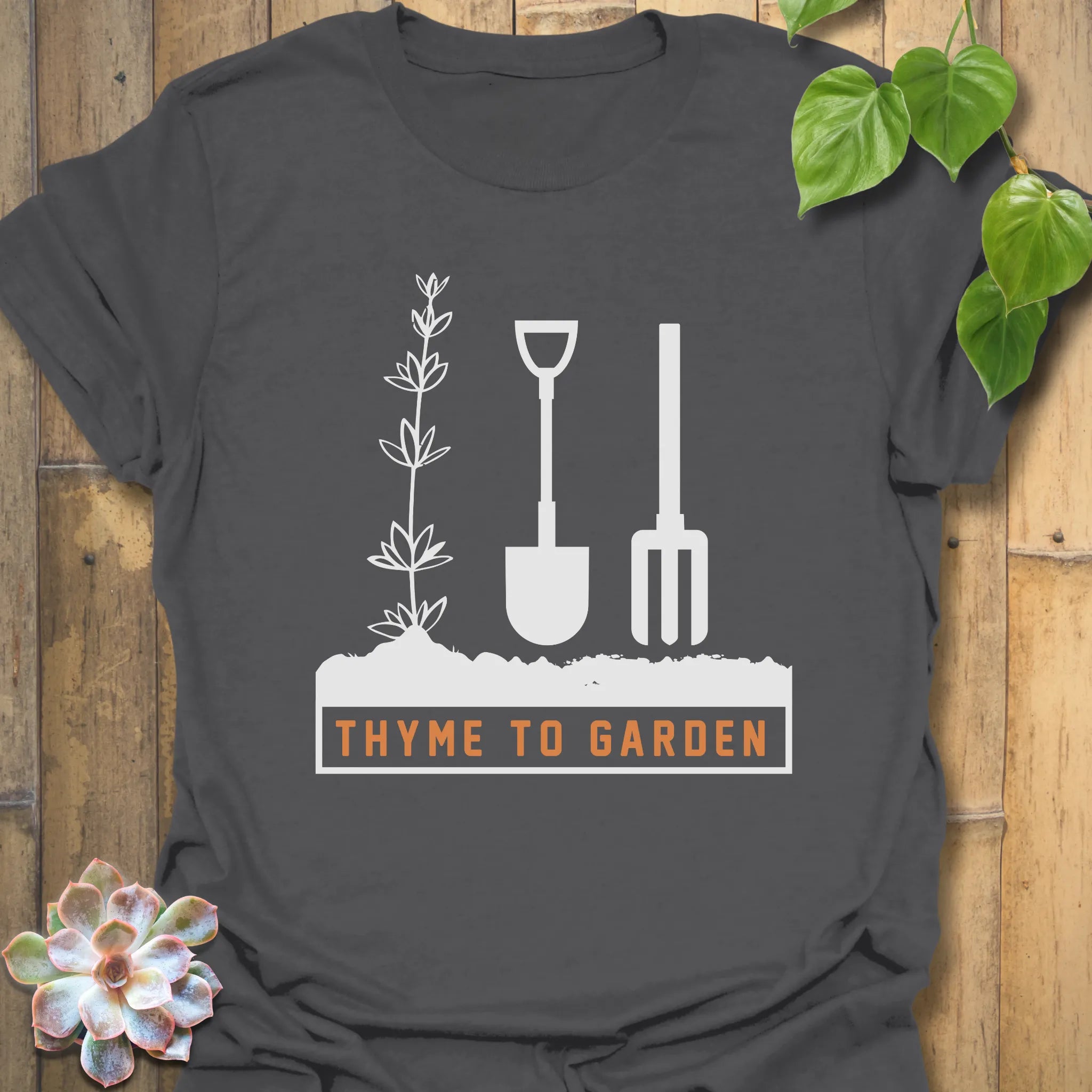 Charcoal t-shirt featuring the design "Thyme To Garden" with garden tool artwork, a stylish eco-friendly shirt for gardening and outdoor lovers.