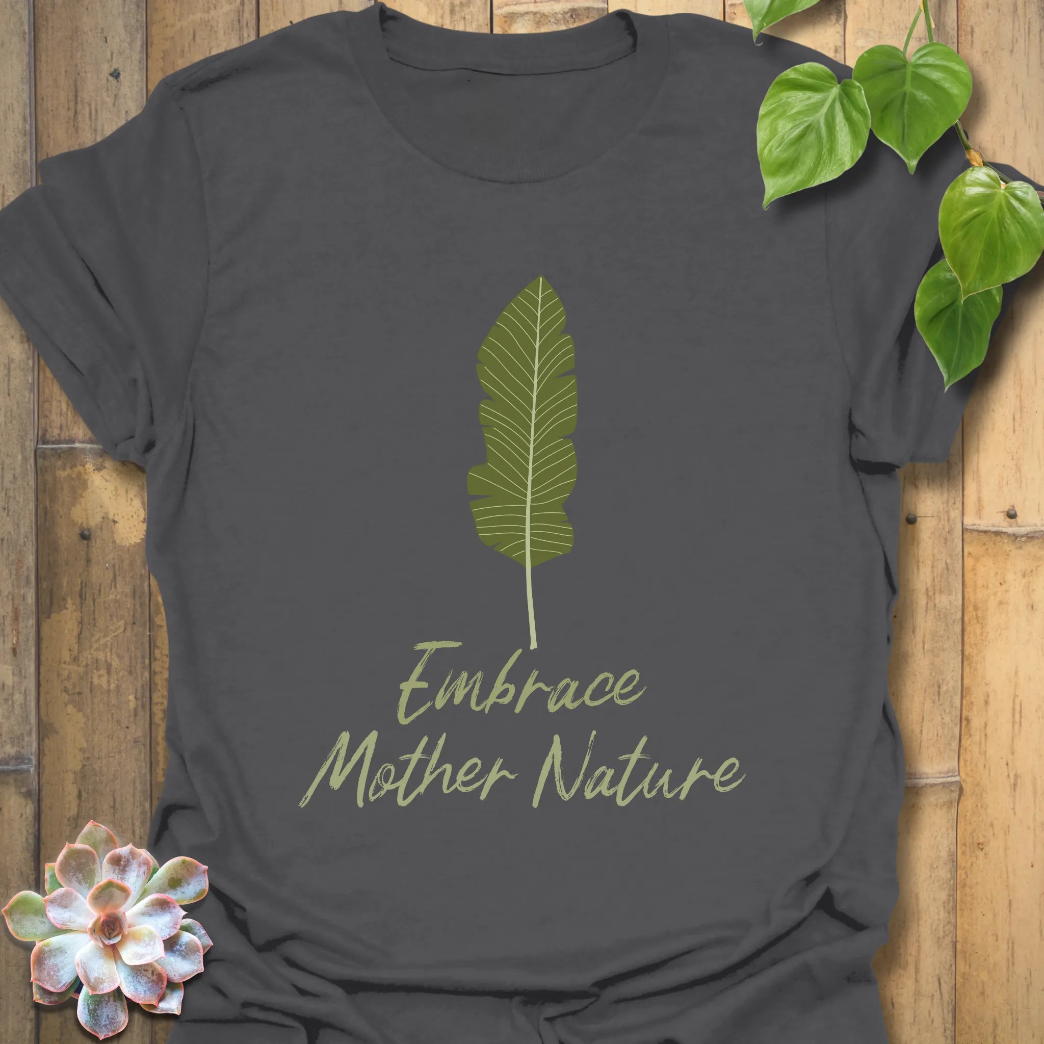 Charcoal t-shirt with the design that reads “Embrace Mother Nature” featuring a decorative leaf print