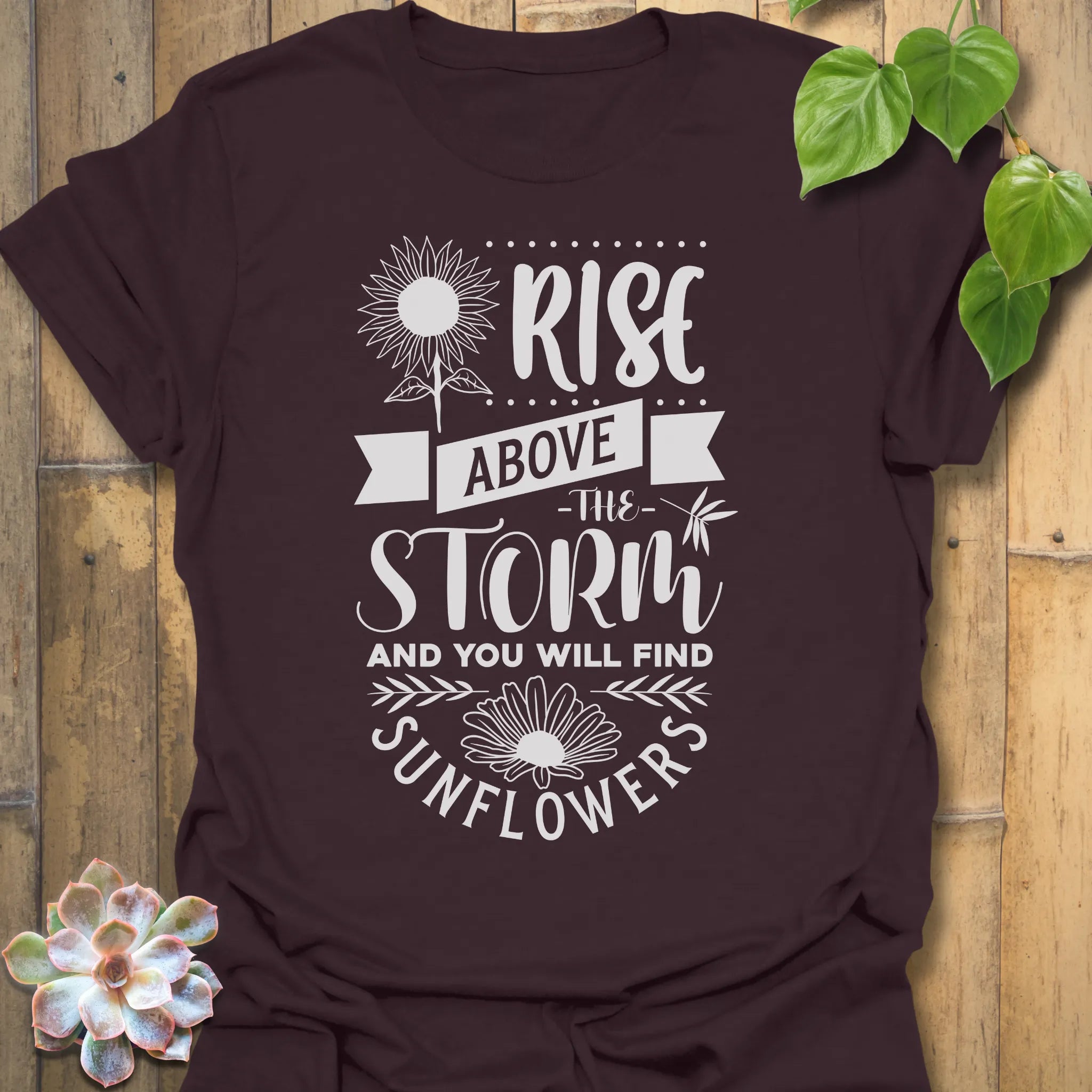 Dark Chocolate t-shirt featuring the design Above The Storm printed in bold letters, floral inspirational sunflower graphic shirt.