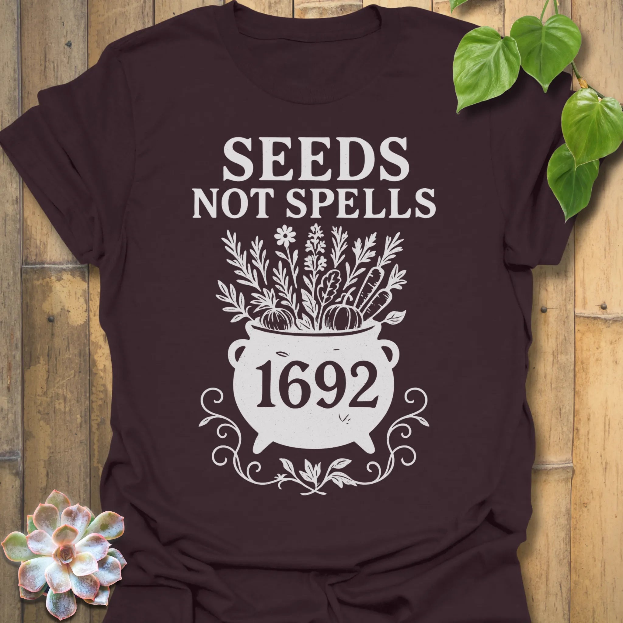 Dark Chocolate t-shirt featuring the design Seeds Not Spells printed in bold letters, halloween plant lover shirt.