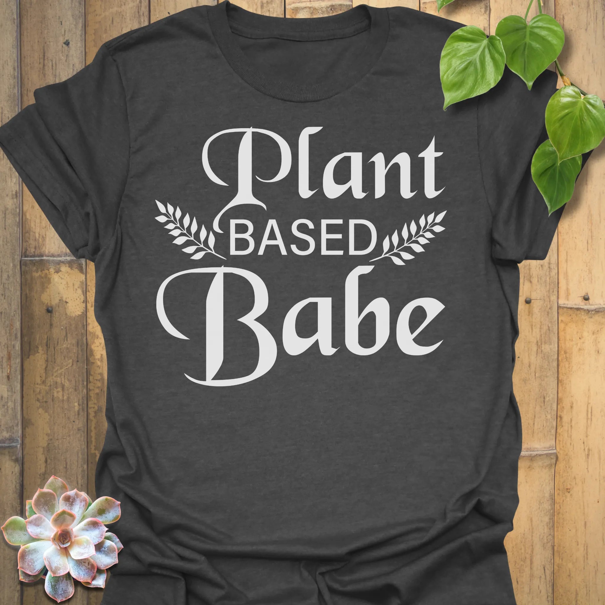 Dark Heather t-shirt featuring the design Plant Based Babe printed in bold white letters, plant lover vegan shirt.