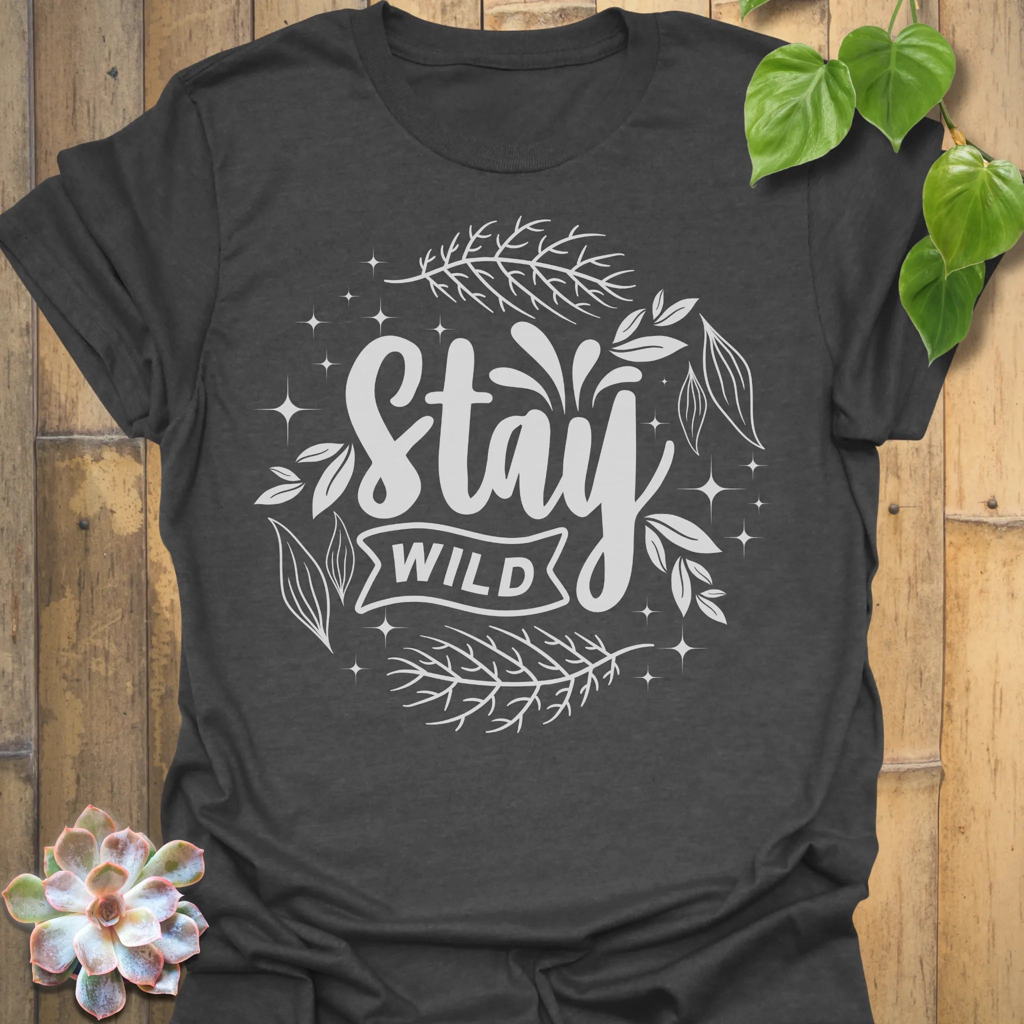 Dark Heather t-shirt featuring the design Stay Wild printed in bold white letters, floral graphic lover shirt.