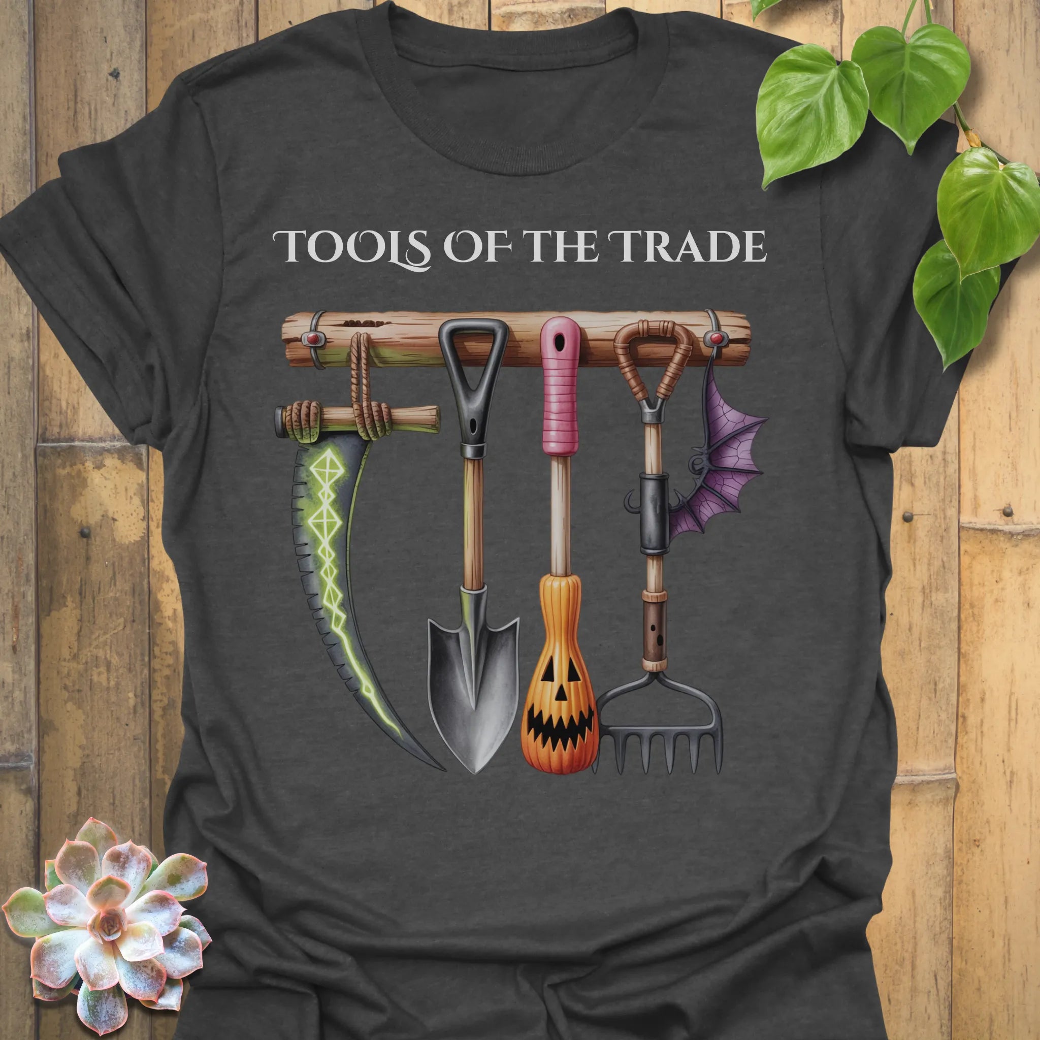 Dark Heather t-shirt featuring the design Tools Of The Trade printed in bold letters, garden tools shirt.