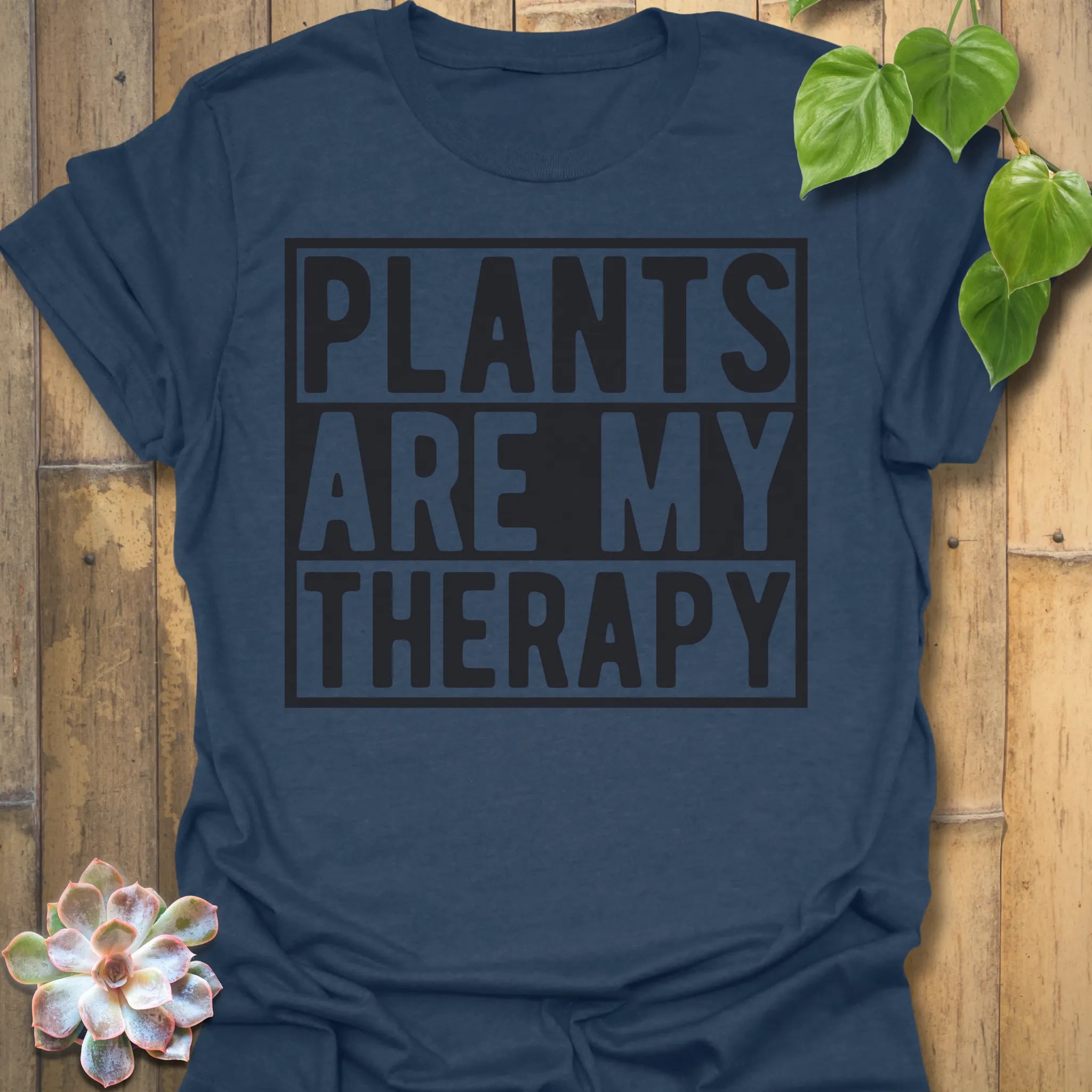 Heather Navy t-shirt featuring the design Plants Are My Therapy printed in bold letters, plant lover shirt.