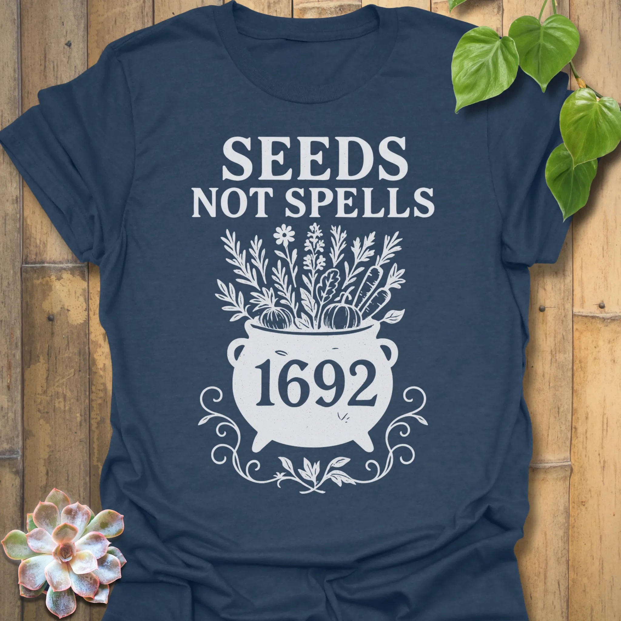 Heather Navy t-shirt featuring the design Seeds Not Spells printed in bold letters, halloween plant lover shirt.