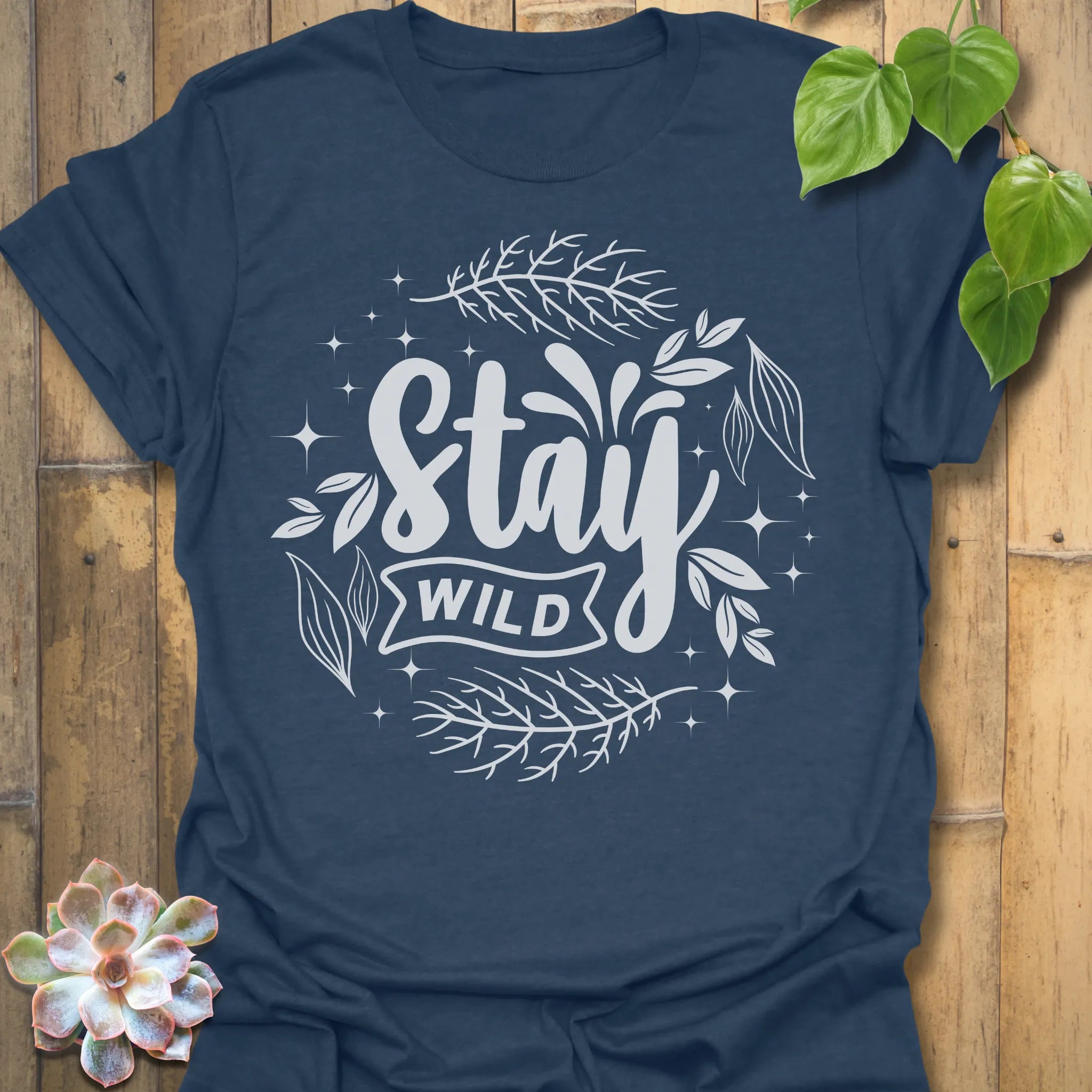 Heather Navy t-shirt featuring the design Stay Wild printed in bold white letters, floral graphic lover shirt.