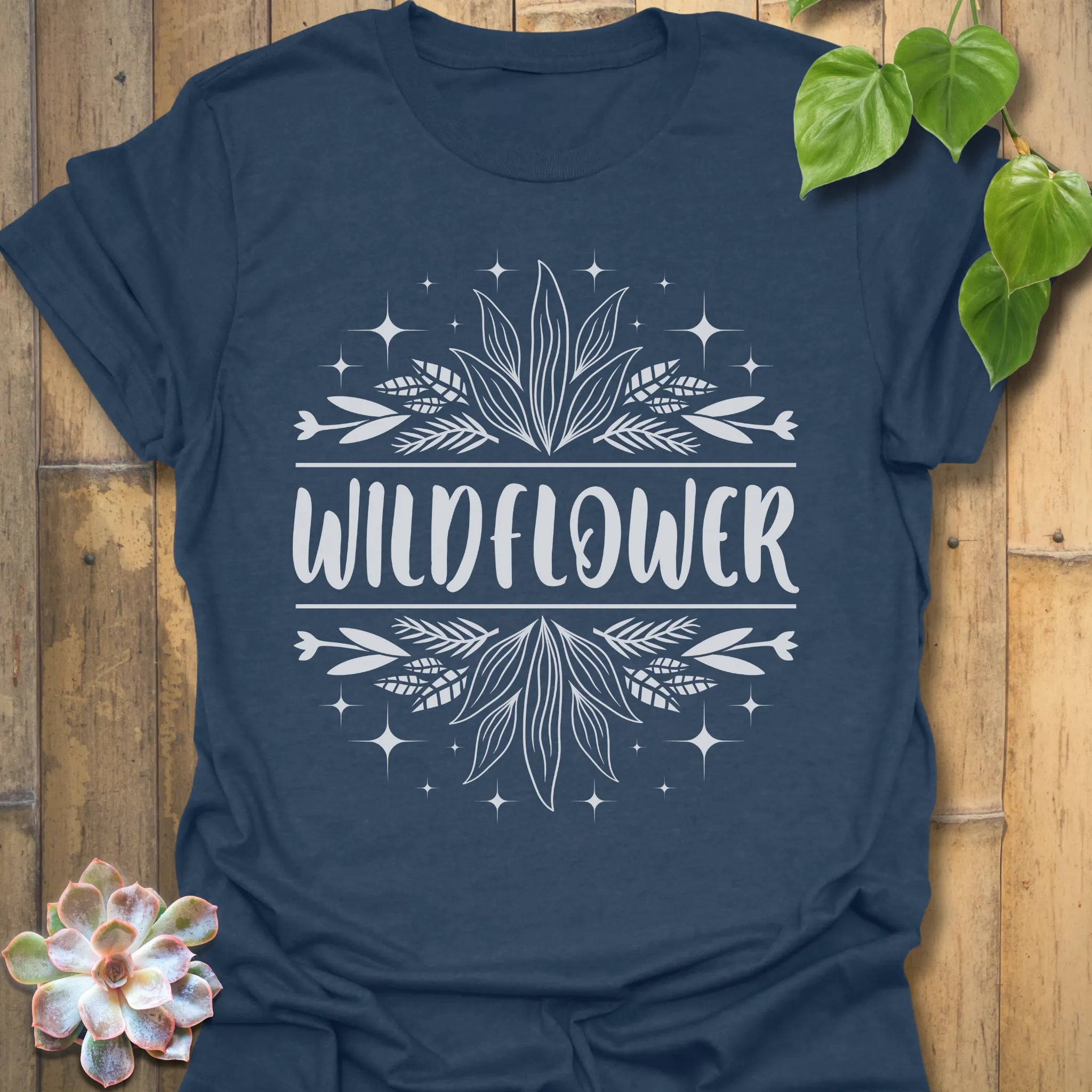 Heather Navy t-shirt featuring the design Wildflower printed in bold white letters, floral graphic shirt.