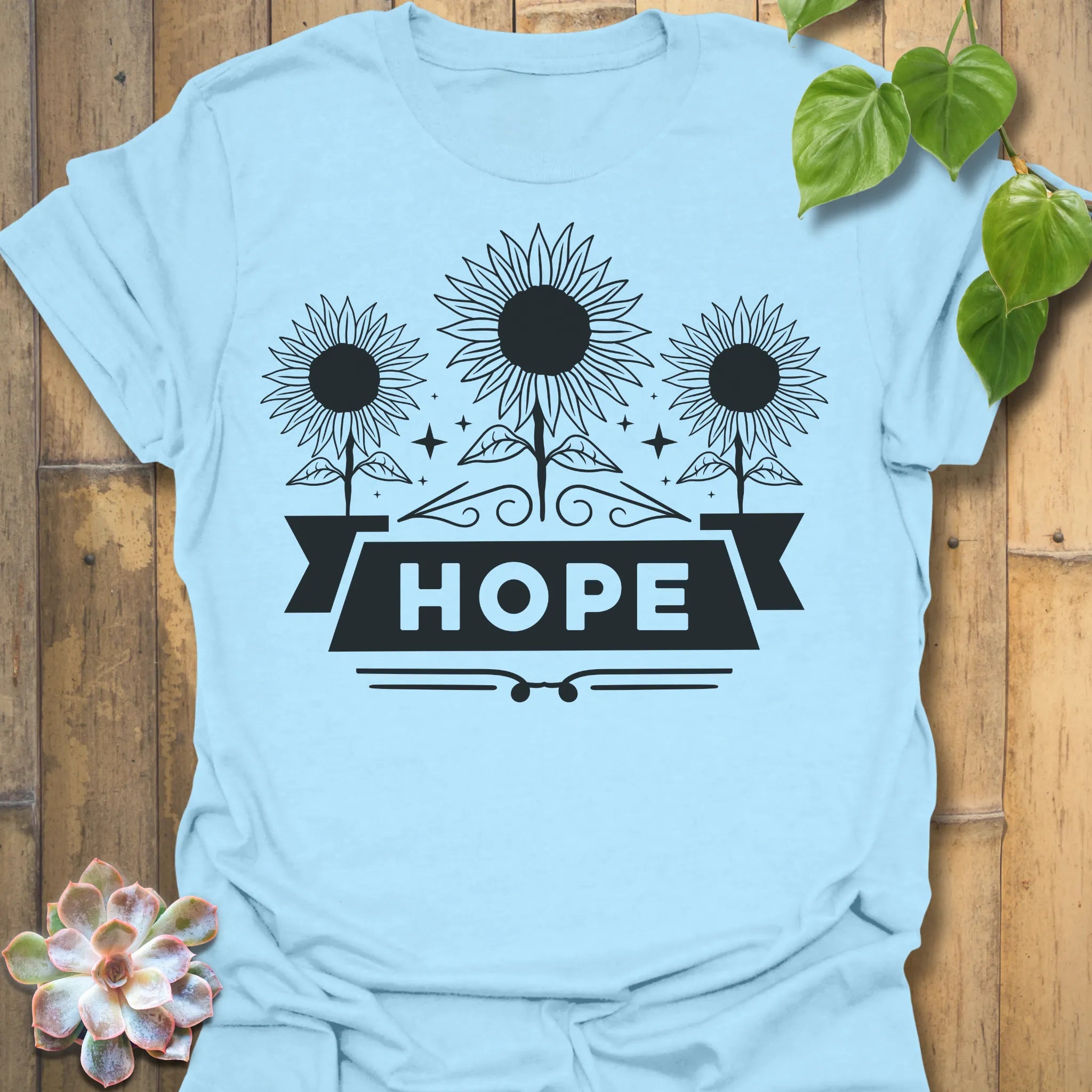 Light Blue t-shirt featuring the design Hope printed in sunflower and bold letters, positive vibe t-shirt.