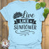 Light Blue t-shirt featuring the design Live Like A Sunflower printed in bold black letters, sunflower lover shirt.