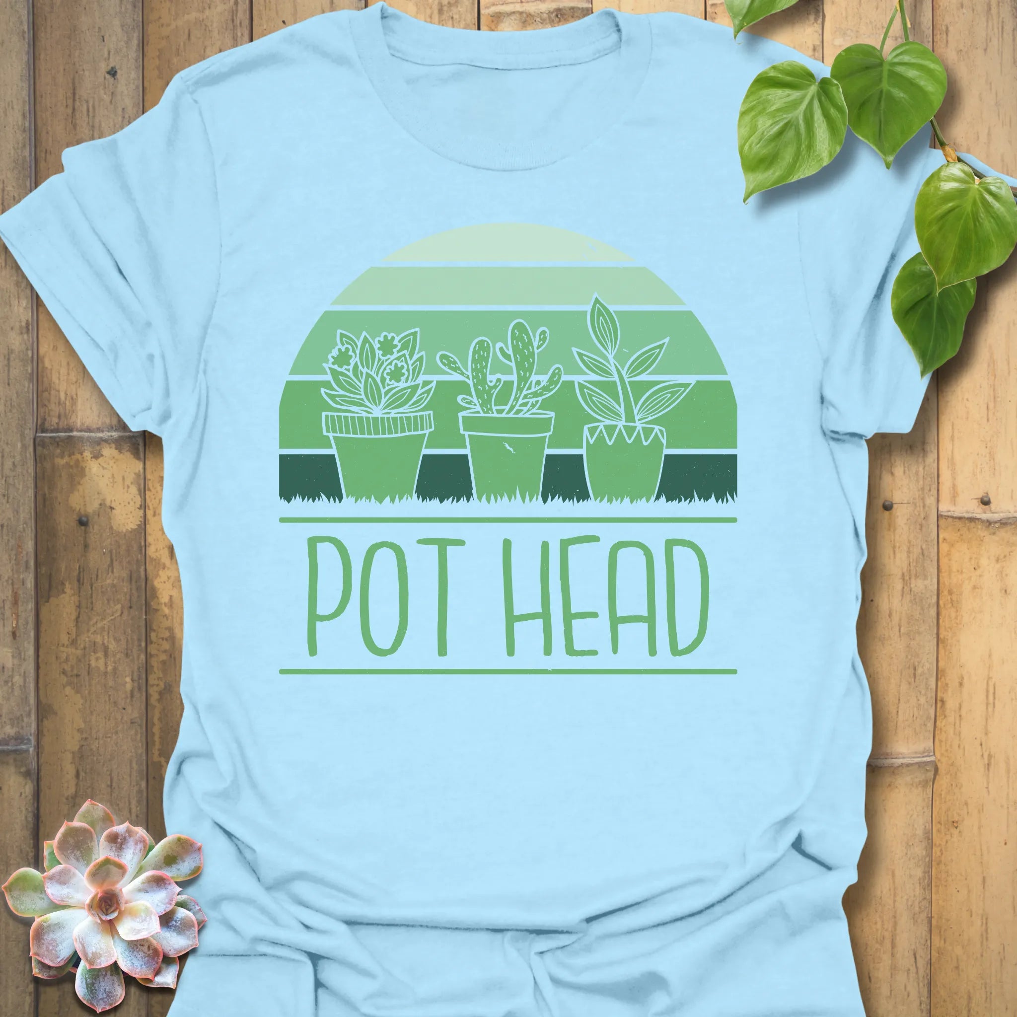 Light Blue t-shirt featuring the design Pot Head printed in bold green letters, garden lover shirt.