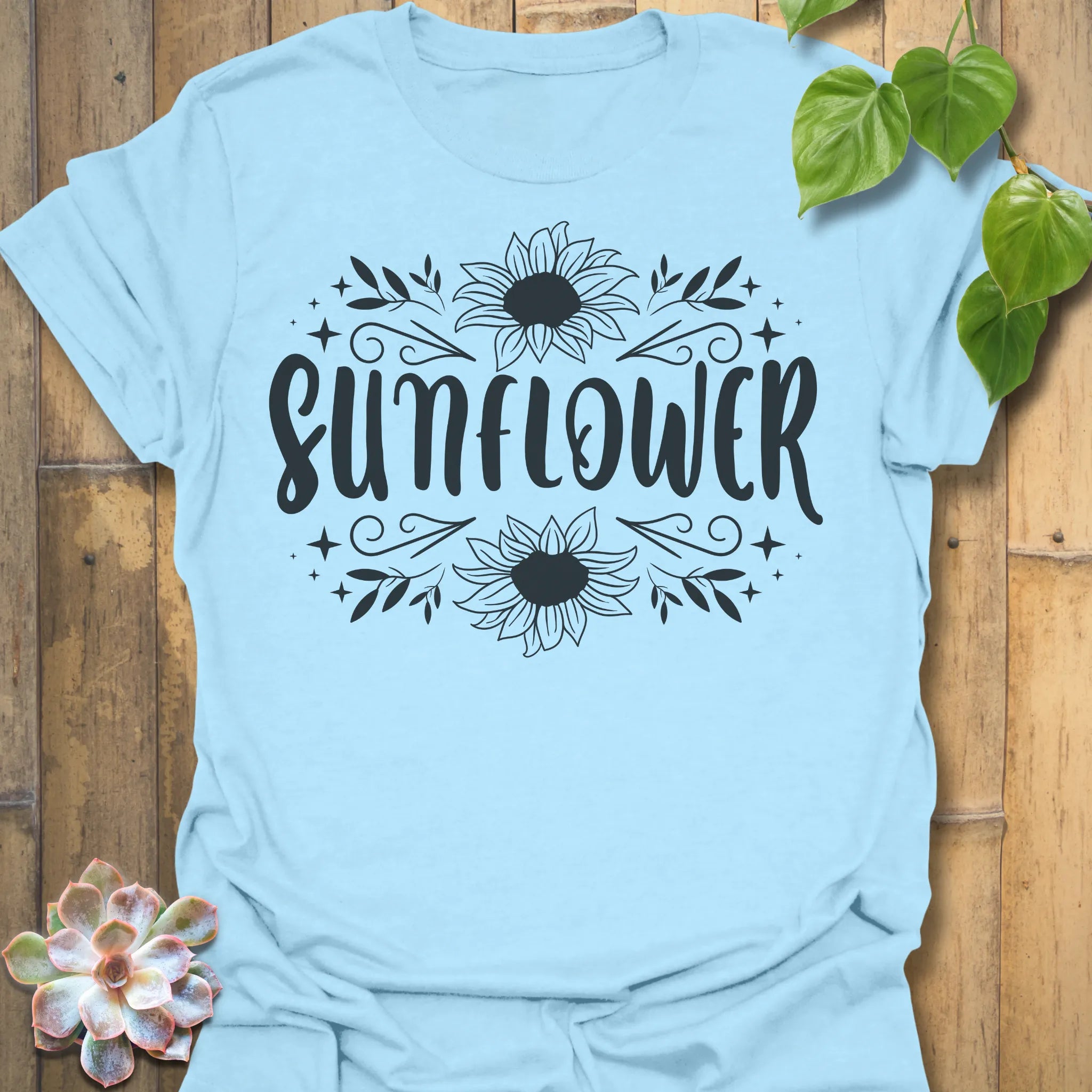 Light Blue t-shirt featuring the design Sunflower printed inbold white, sunflower floral graphic tee.