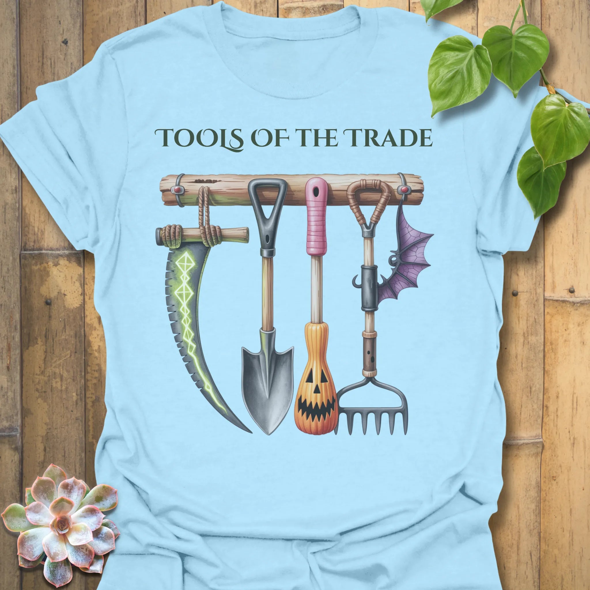 Light Blue t-shirt featuring the design Tools Of The Trade printed in bold letters, garden tools shirt.
