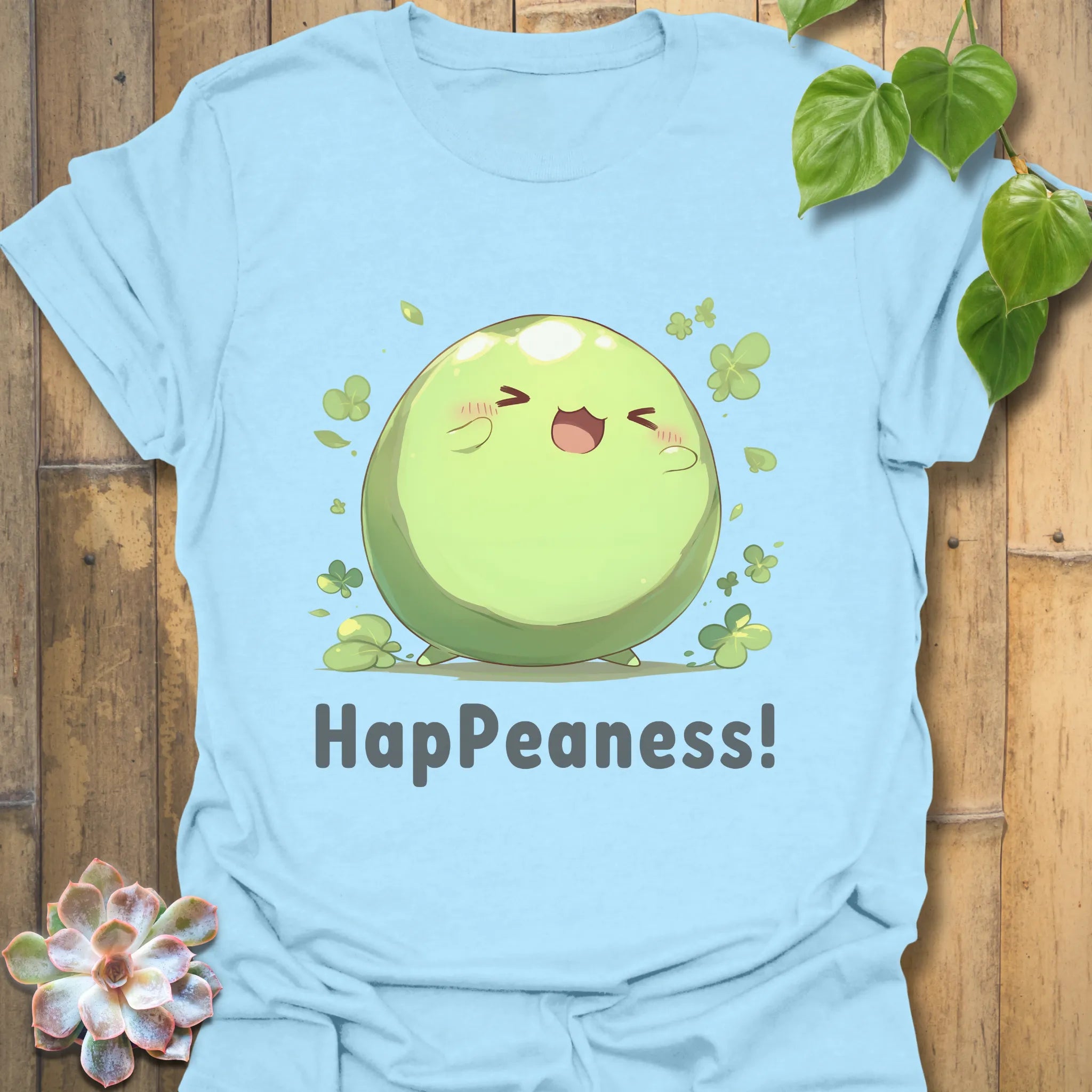 Light blue t-shirt displaying a cheerful green pea cartoon with the word “HapPeaness!” underneath