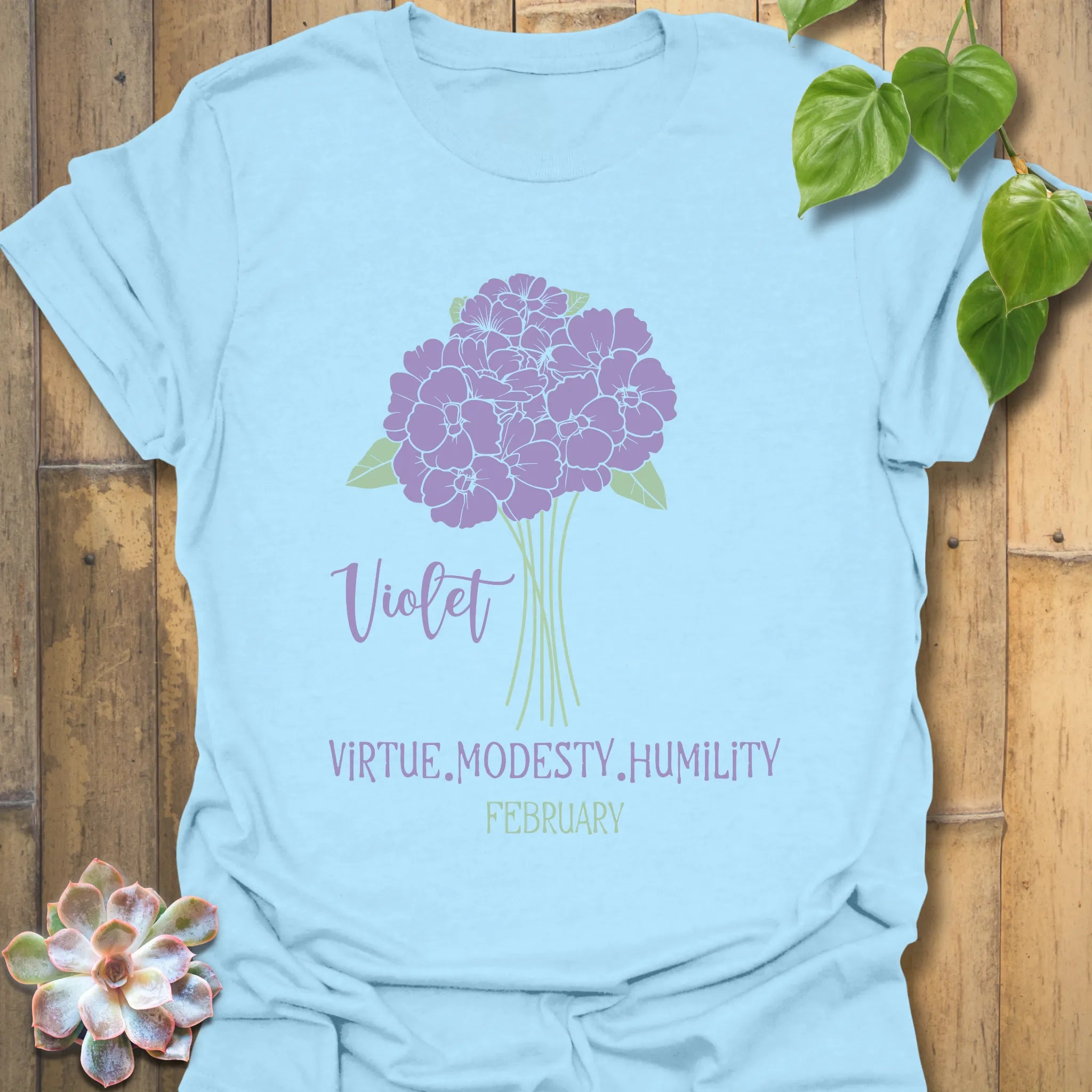 Light blue t-shirt featuring the design February Violet with a rose flower print, a soft pastel floral graphic t-shirt for women and men.