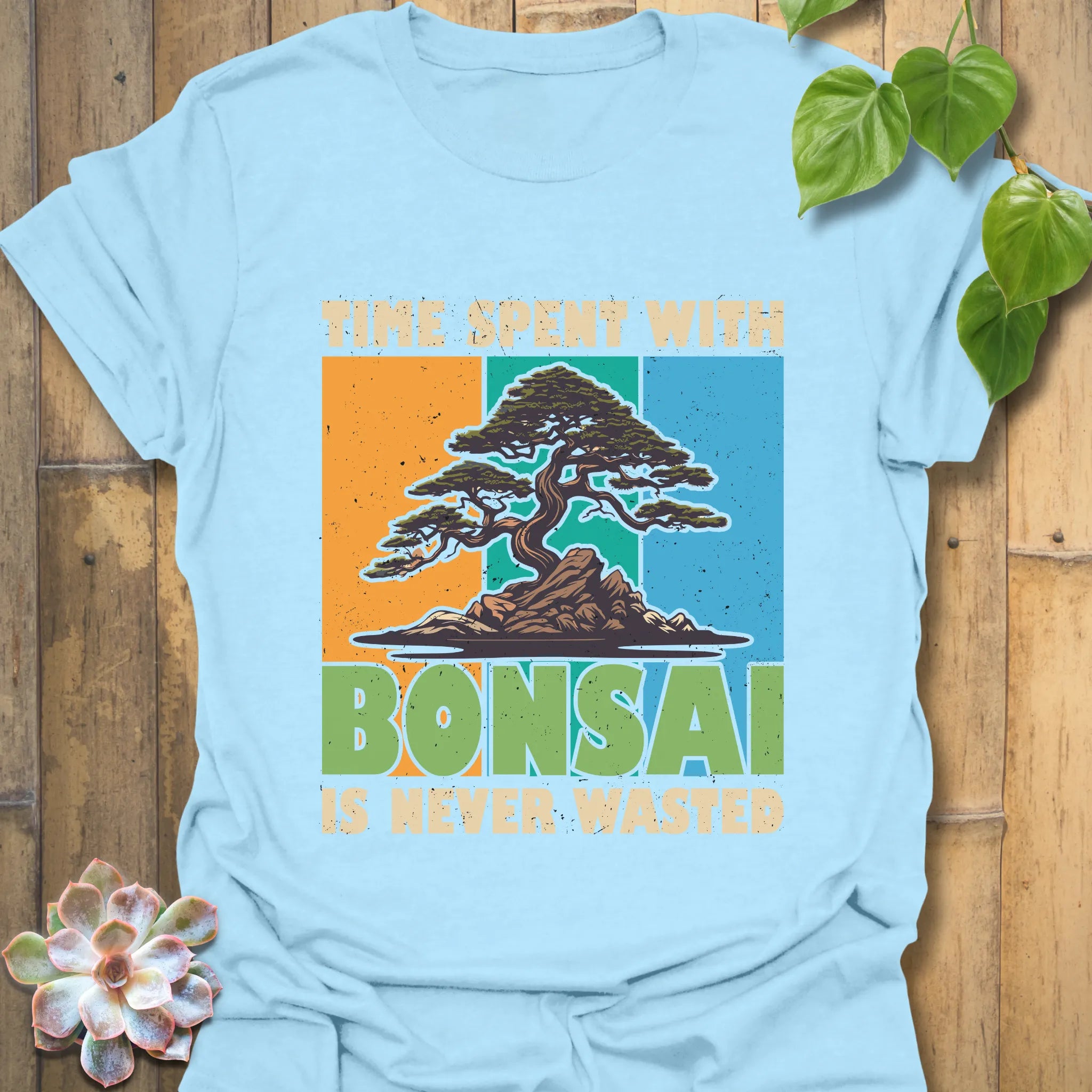 Light blue t-shirt featuring the design “Time spent with bonsai is never wasted” with a bonsai plant print, stylish casual wear for bonsai enthusiasts.