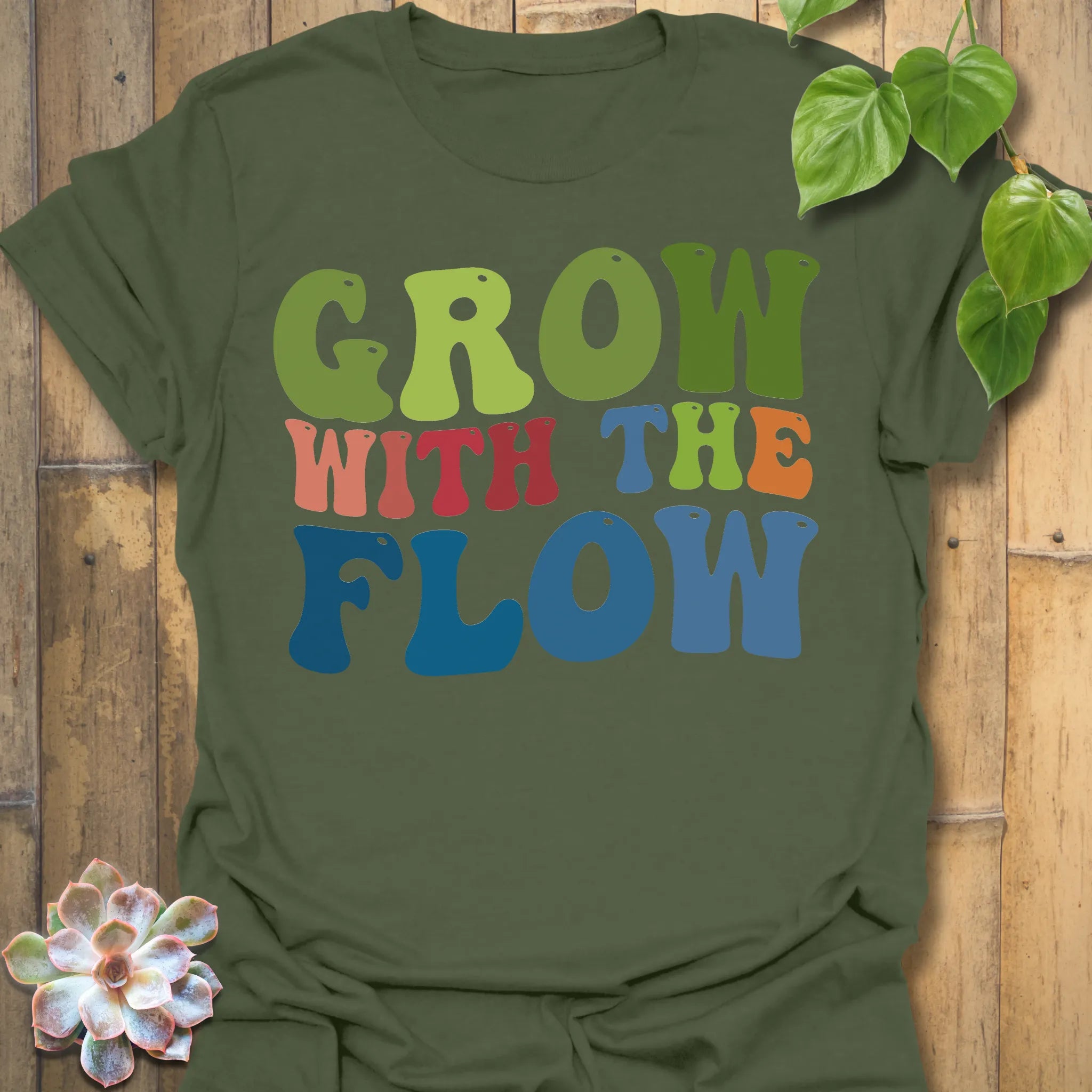 Military Green t-shirt featuring the design Grow With The Flow printed in bold colorful letters, mindful garden shirt.