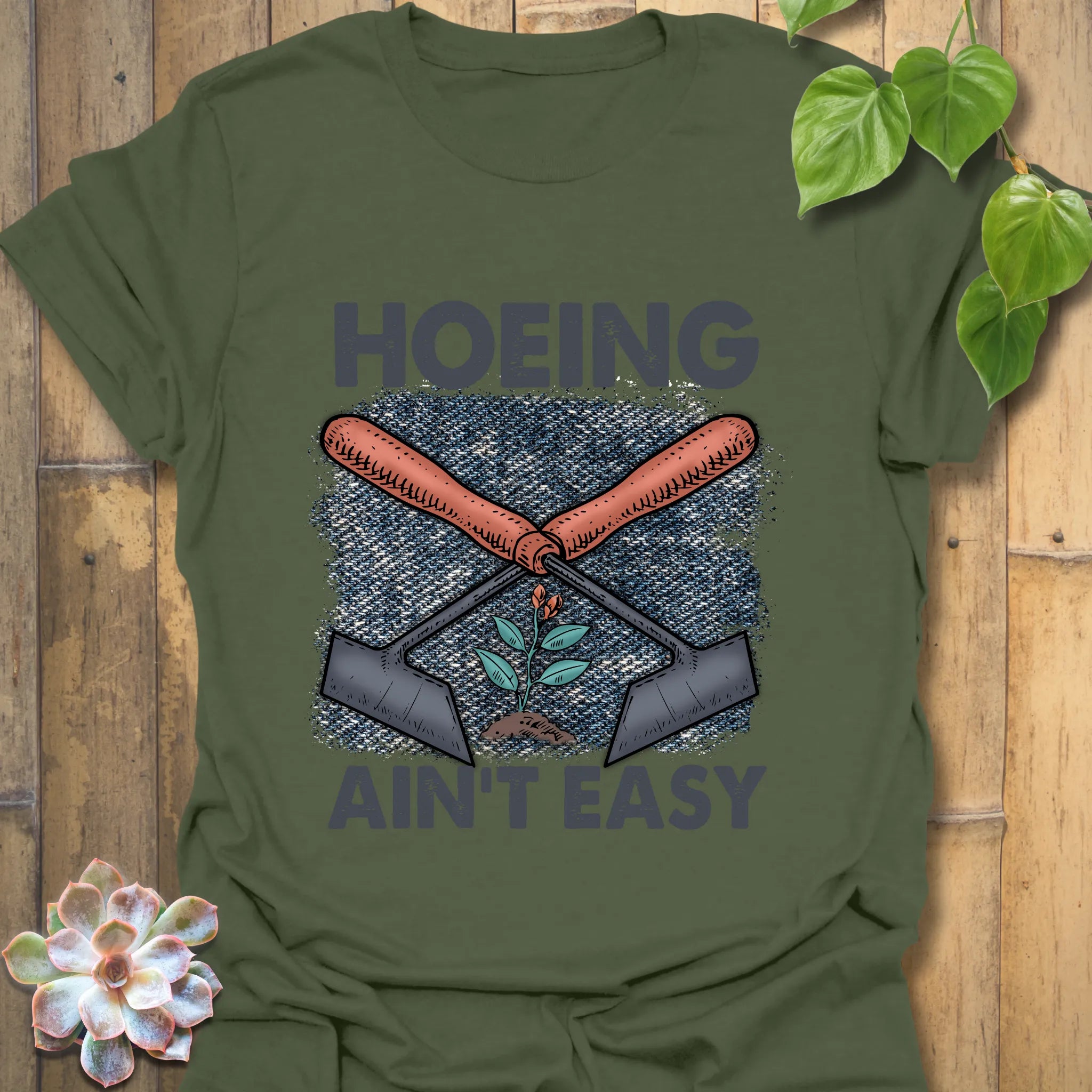 Military Green t-shirt featuring the design Hoeing Ain’t Easy, outdoor gardening humour shirt.