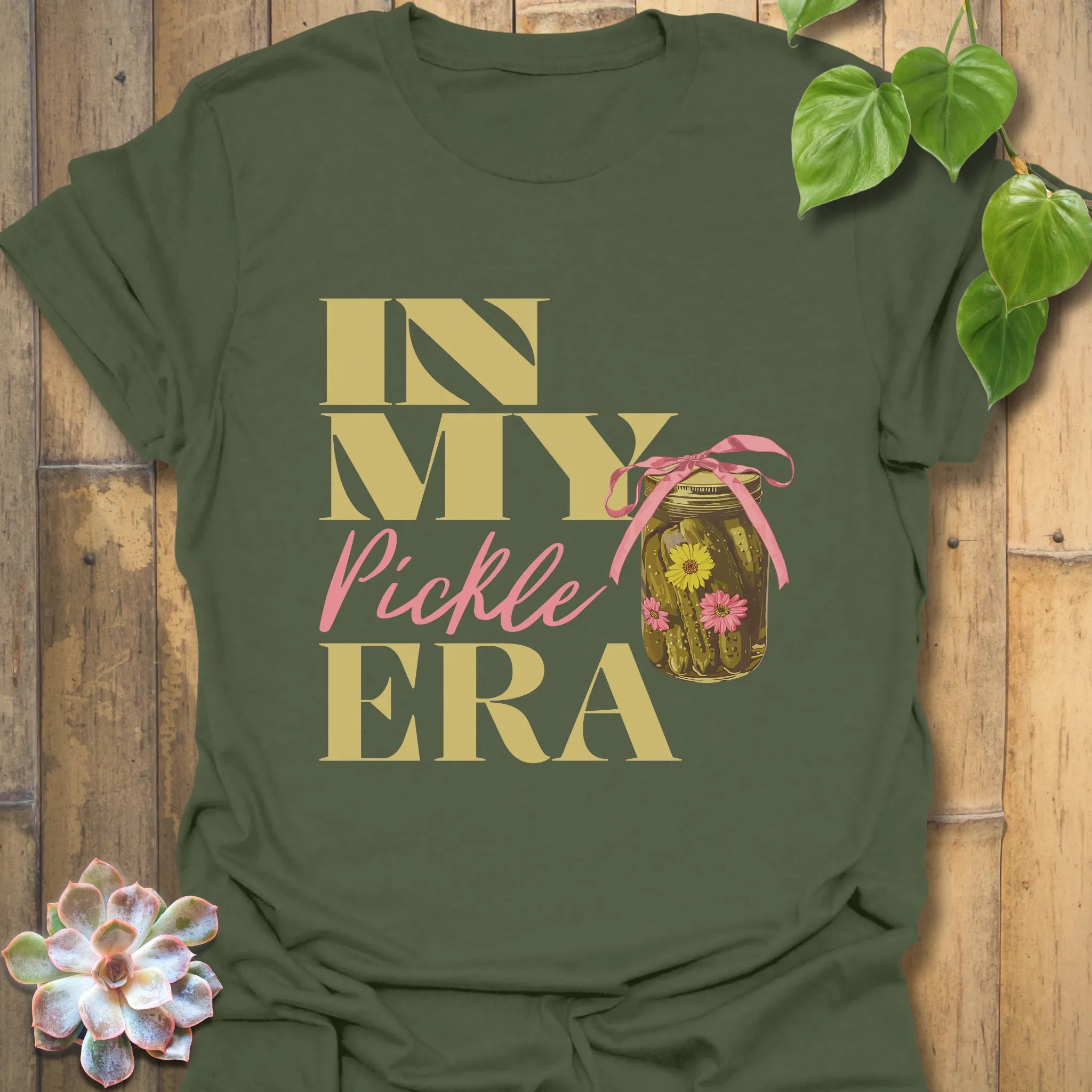 Military green t-shirt displaying the playful “In My Pickle ERA” design with cucumbers inside a jar