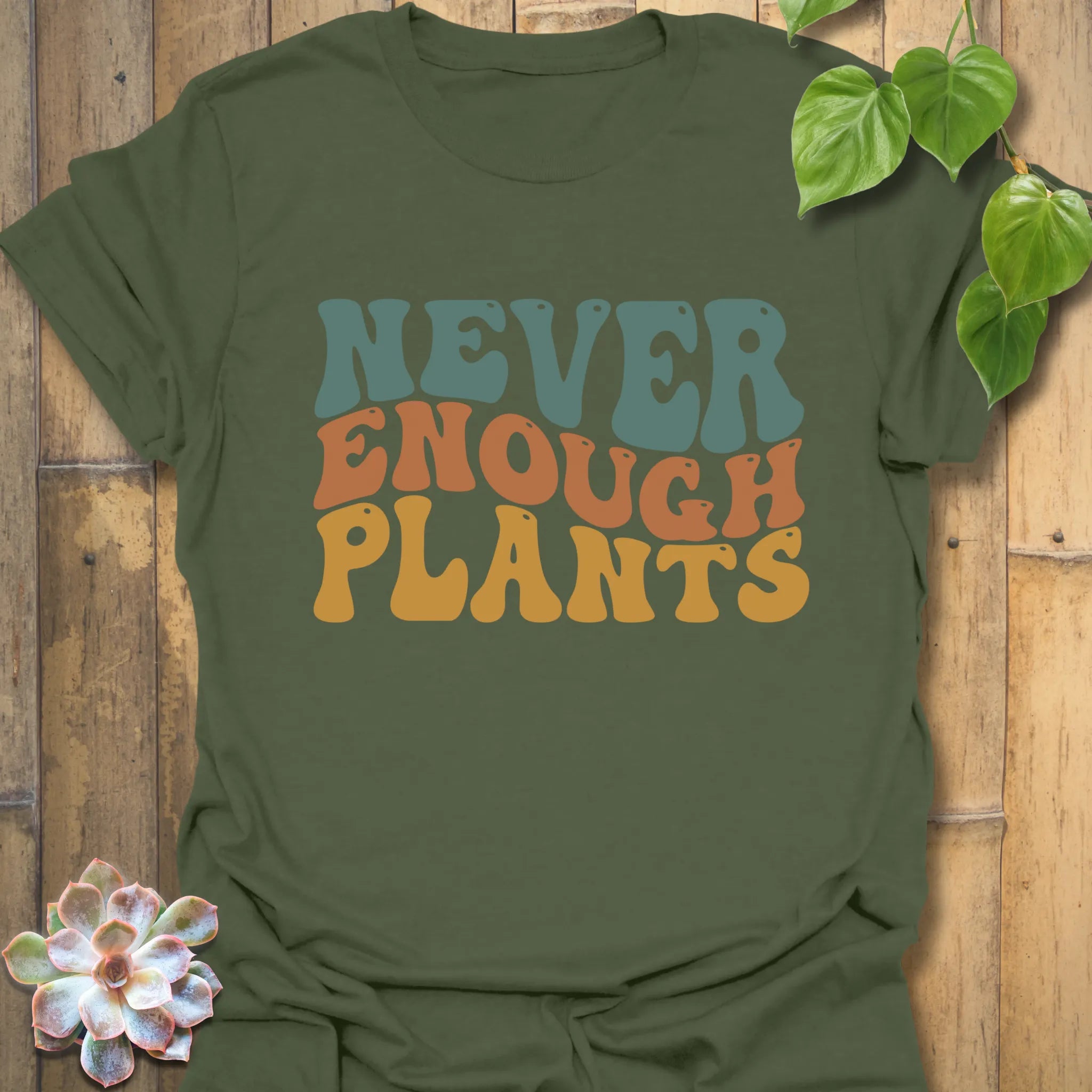 Military green t-shirt featuring the design Never Enough Plants in bold green text with a leafy accent.