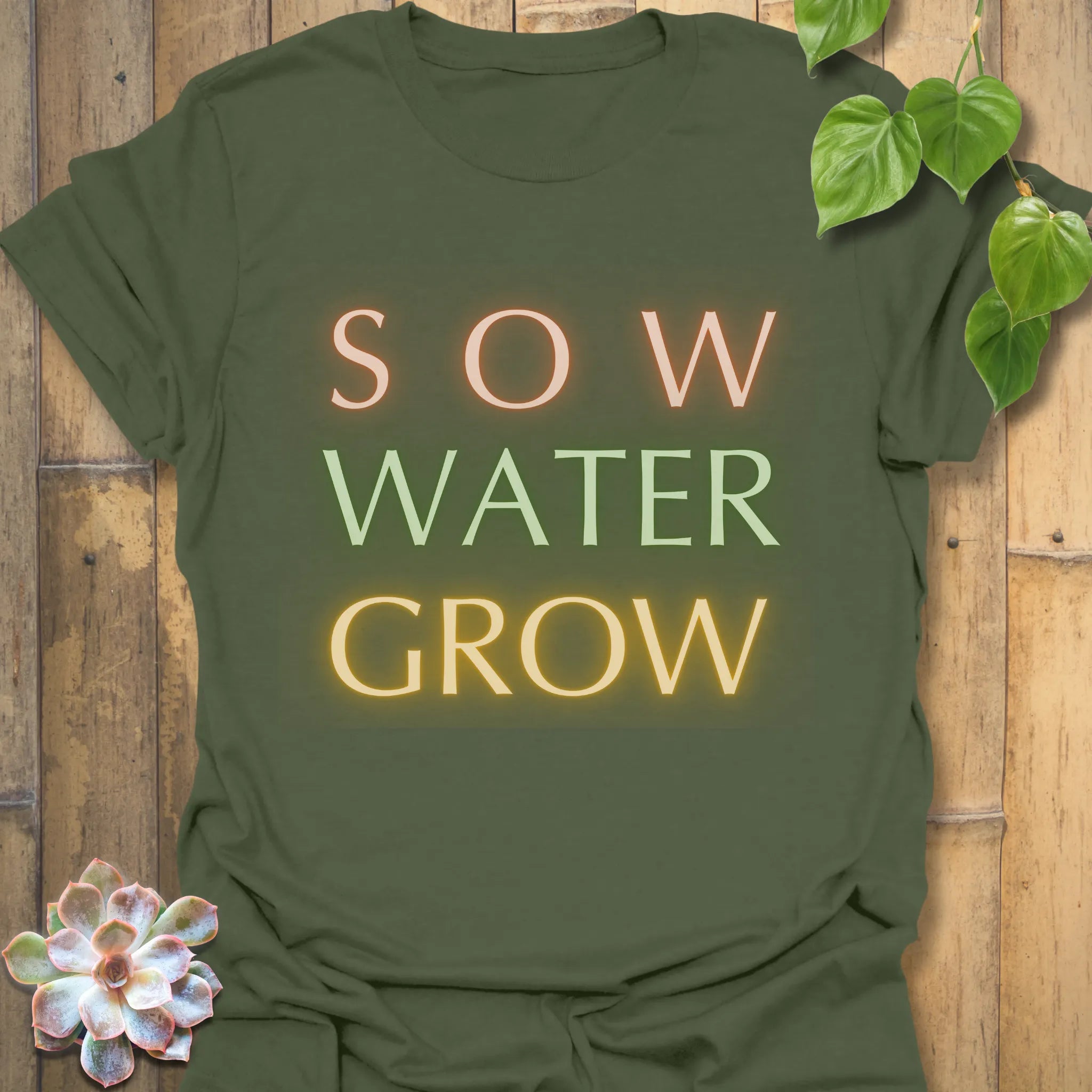 Military green t-shirt featuring the design Sow Water Grow printed with nature-inspired plant artwork.