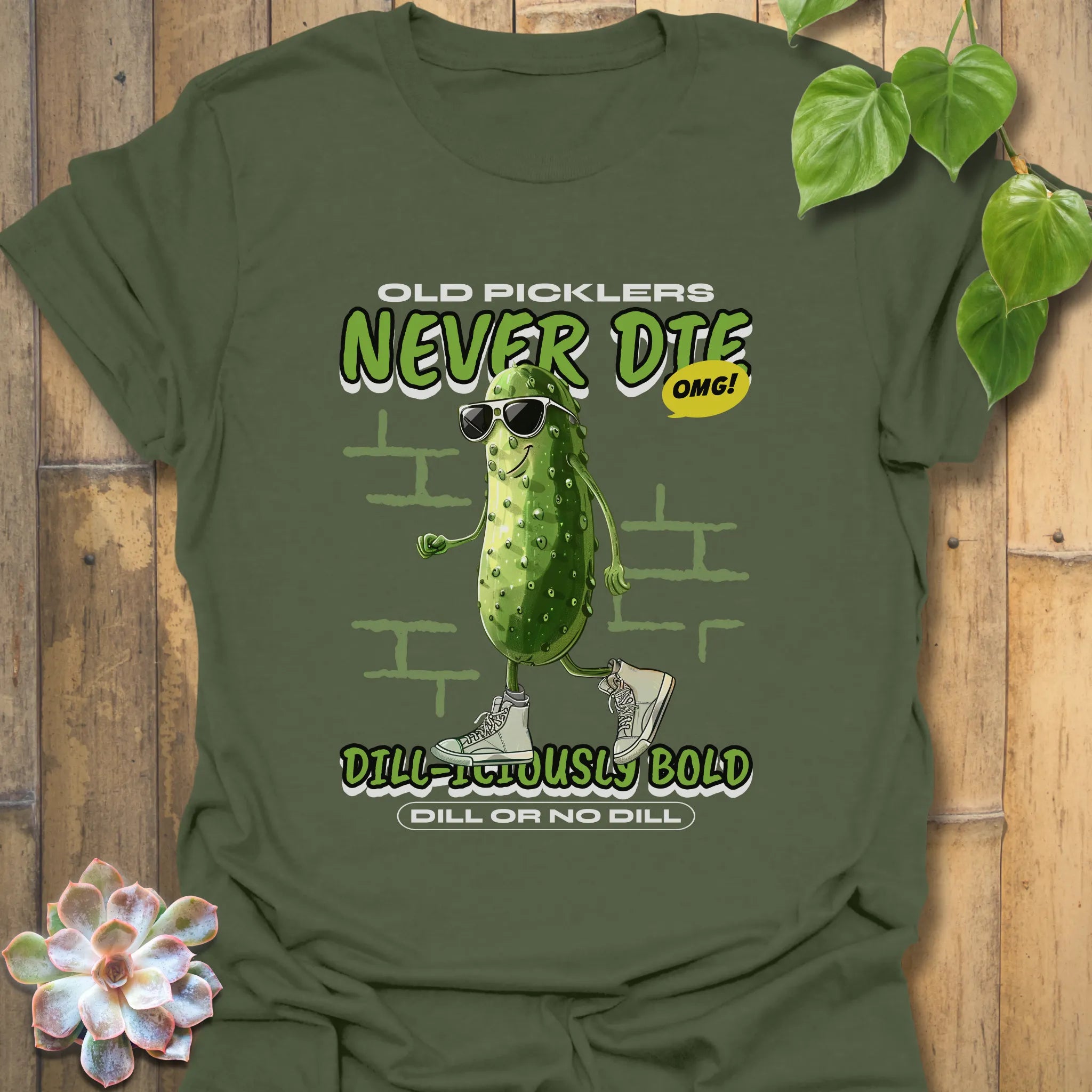 Military green t-shirt with the phrase “Old Pickles Never Die Dill-Iliously Bold” and a cucumber styled like a man in sunglasses