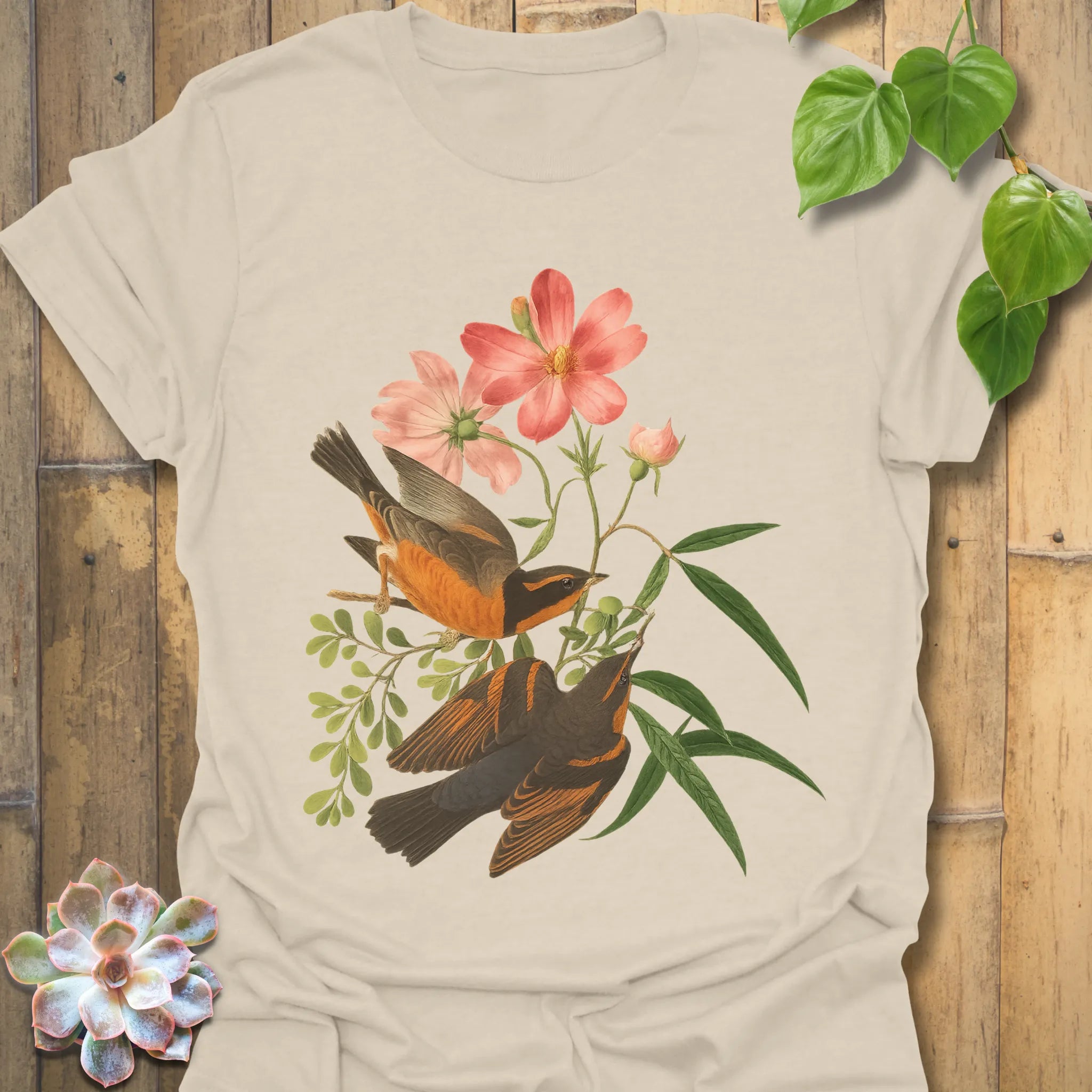 Natural colour t-shirt featuring the Spring Songbirds design with two birds among pink blossoms and leafy stems