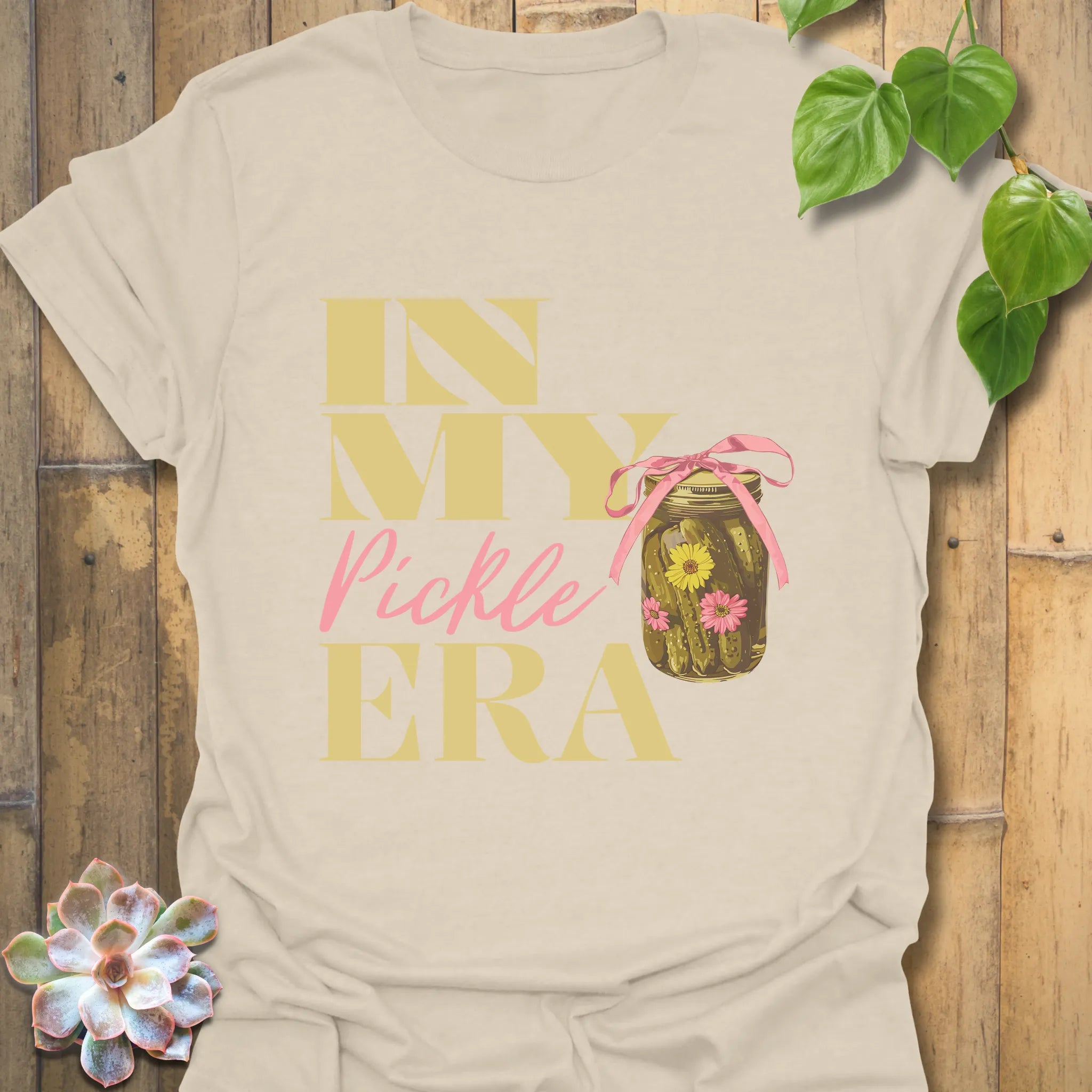 Natural colour t-shirt featuring the design “In My Pickle ERA” with cucumbers inside a glass jar