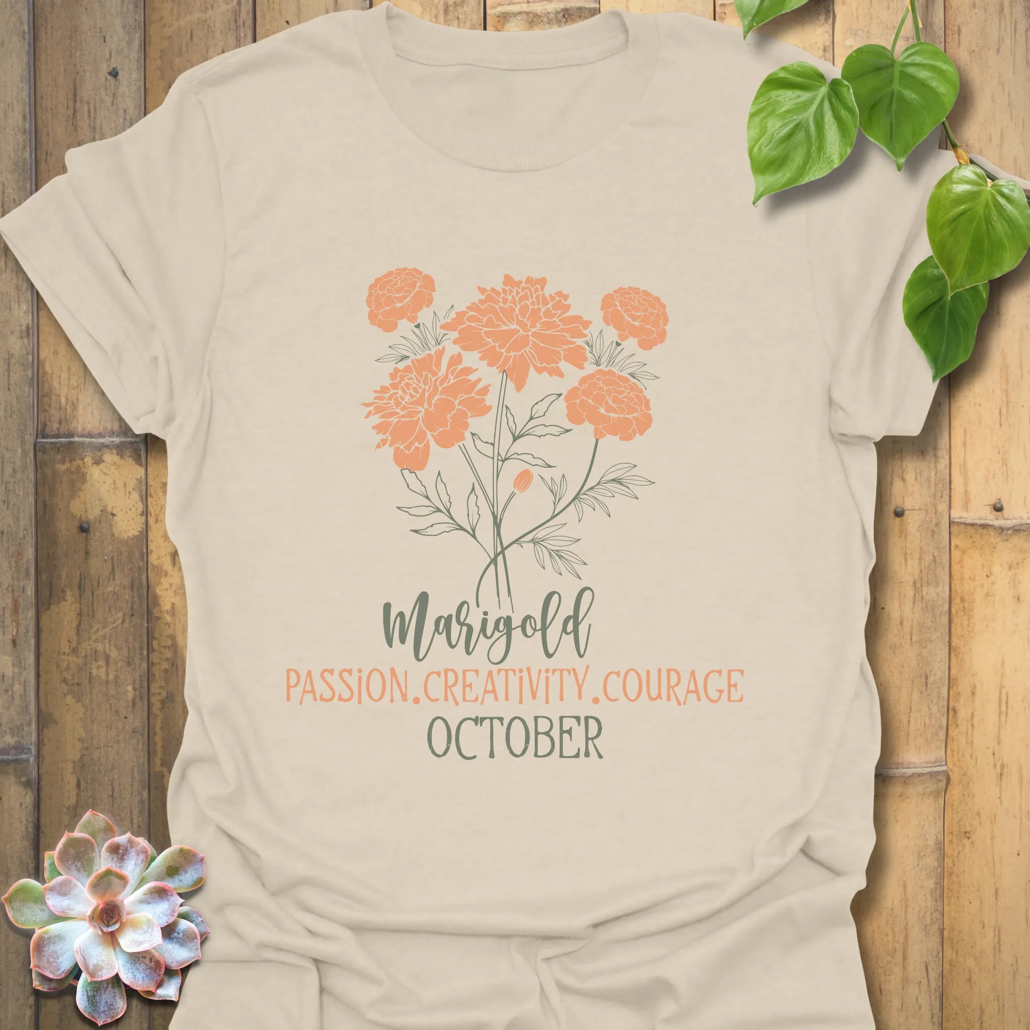 Natural t-shirt featuring the design October Marigold printed with a golden marigold flower, ideal for a botanical graphic shirt.