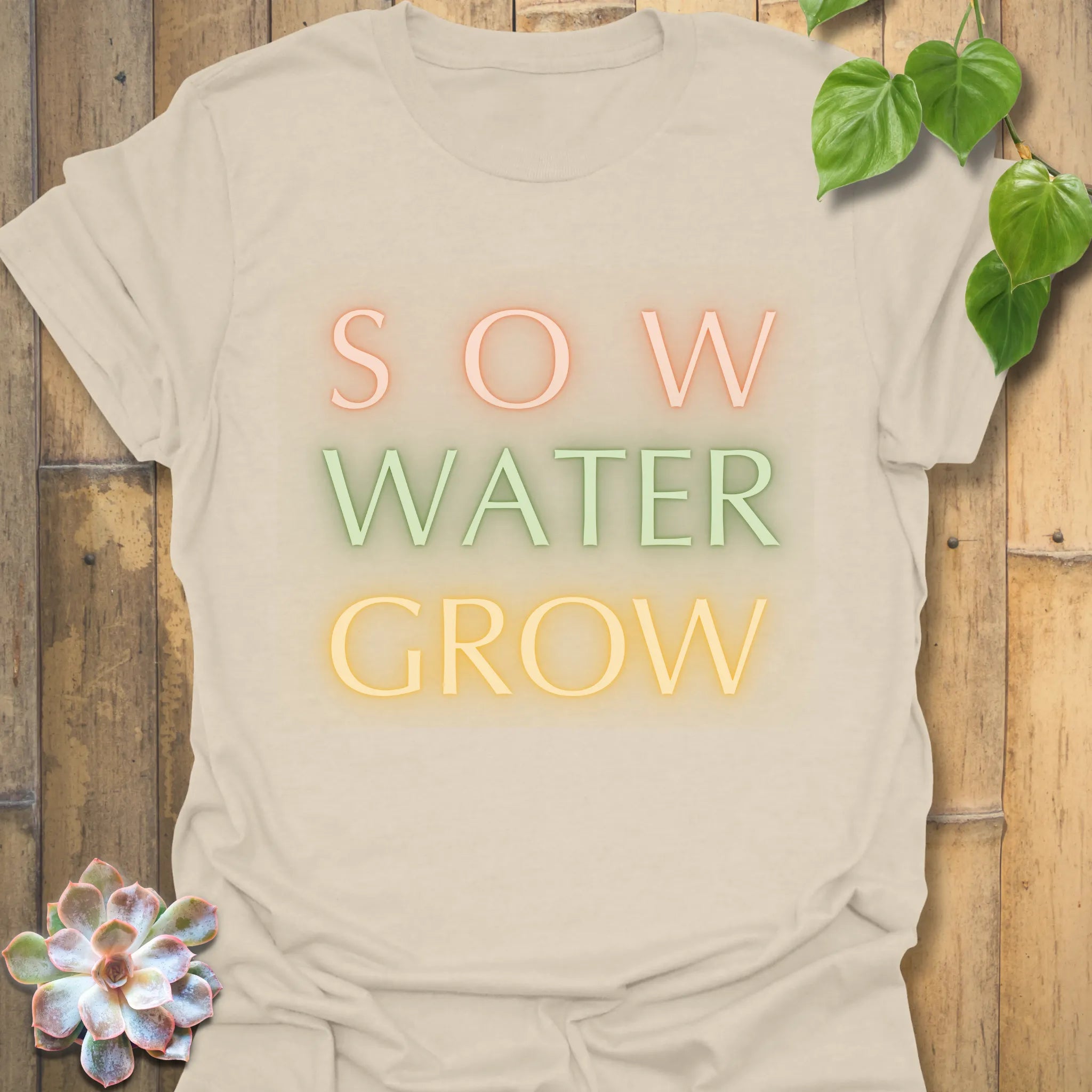 Natural t-shirt featuring the design Sow Water Grow printed with a gardening plant graphic.